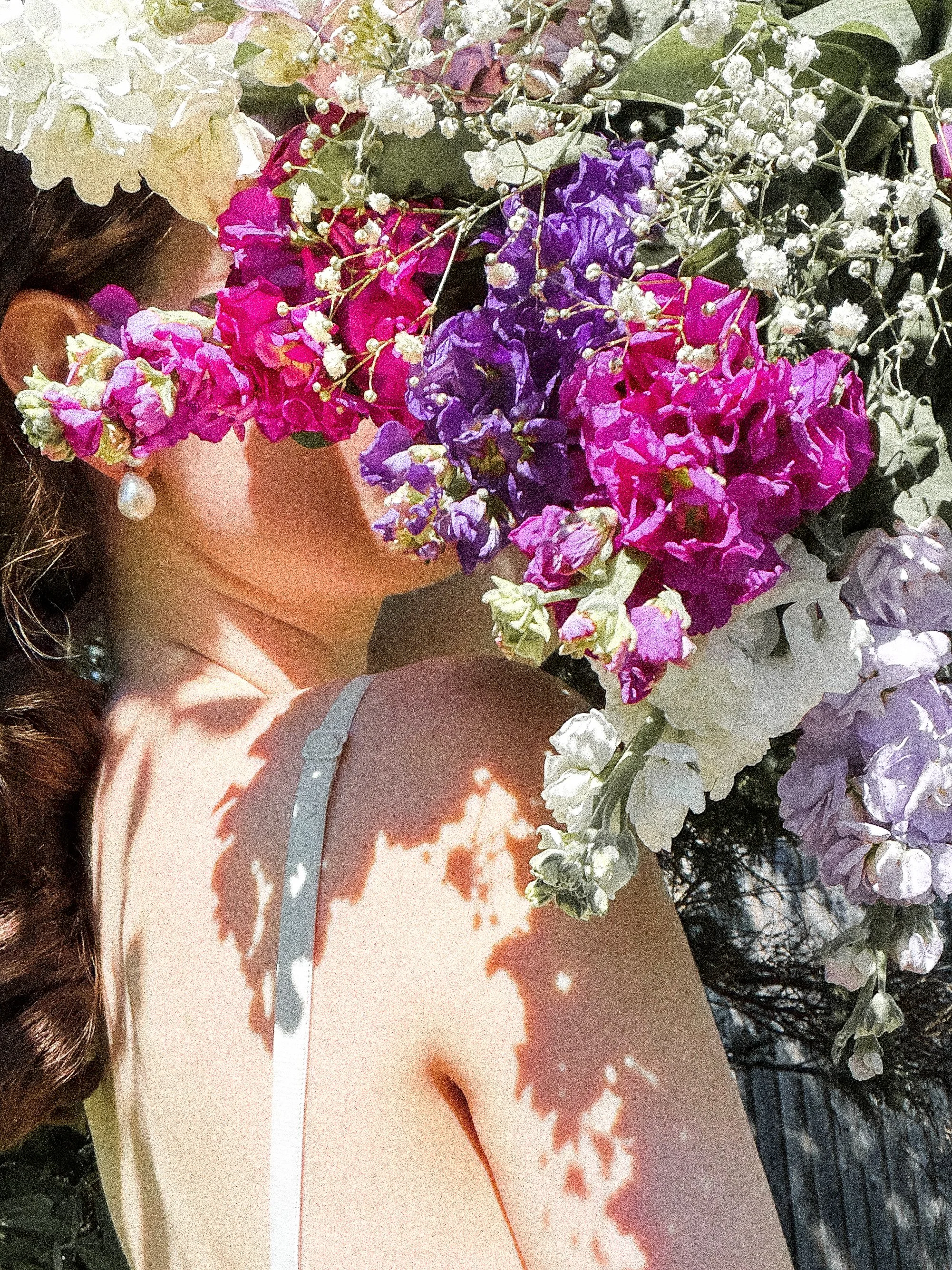 Image of woman holding a bouquet of purple flowers.
