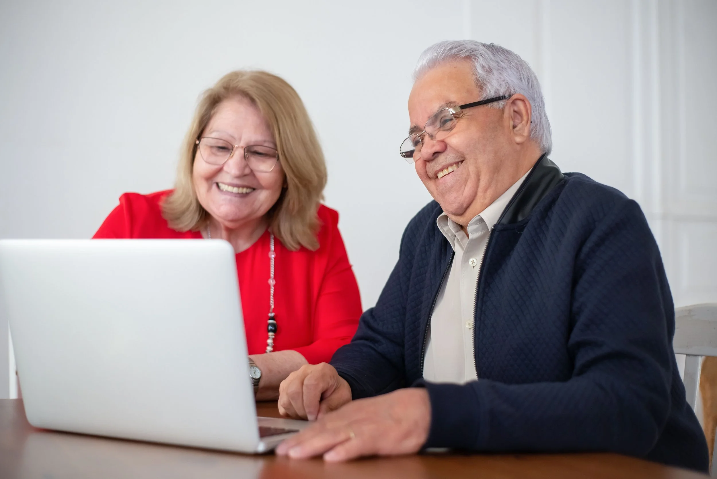 Couple looking at a computer and smiling during an assessment