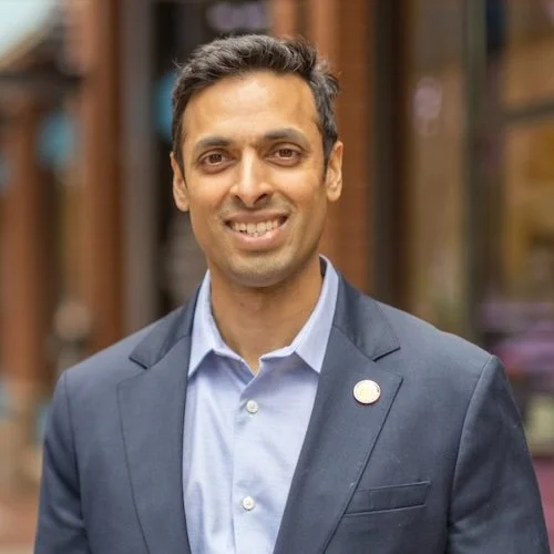 Portrait of a smiling man in a suit outdoors.
