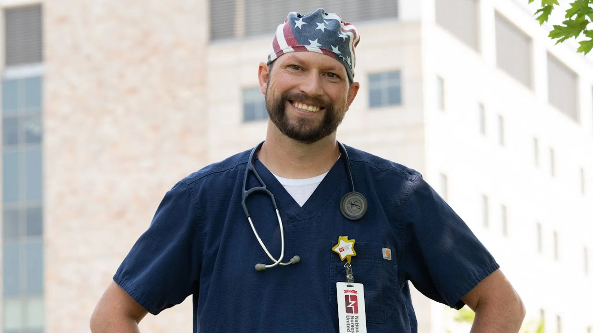 Headshot of Mitchell Berman standing in front of hospital in his uniform