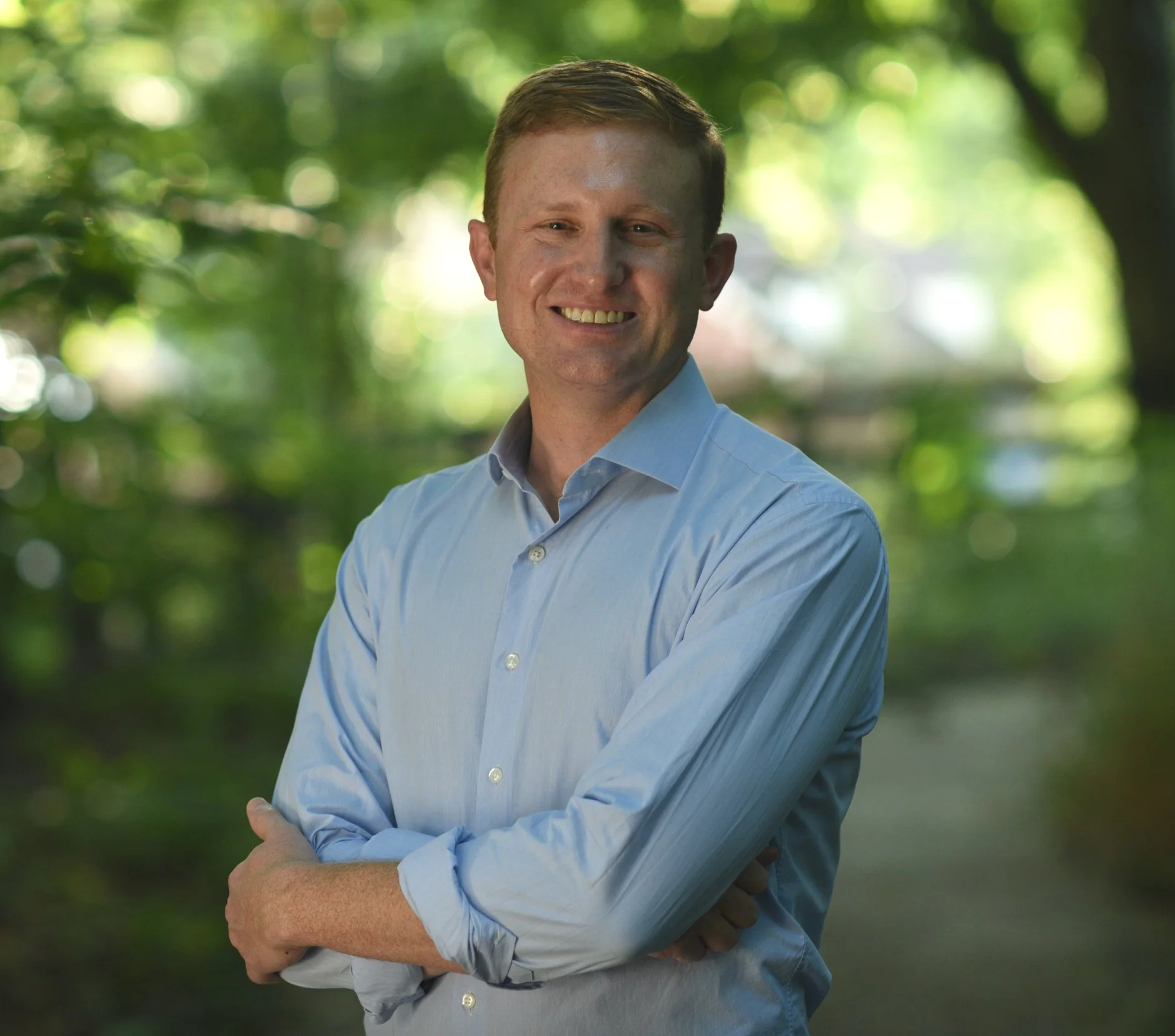 Headshot of Zach Dembo standing with his arms crossed smiling
