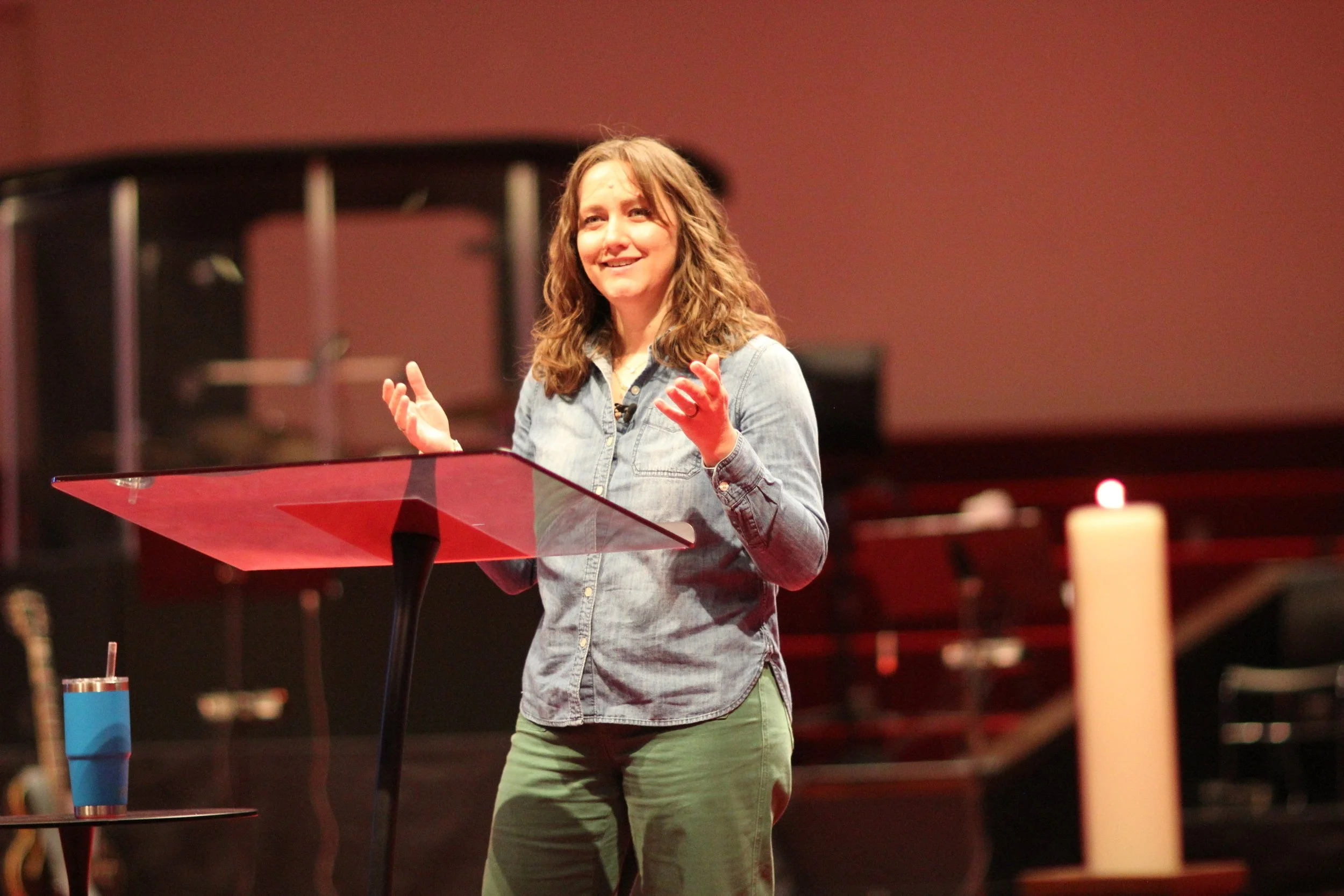 Stephanie on stage at a podium speaking