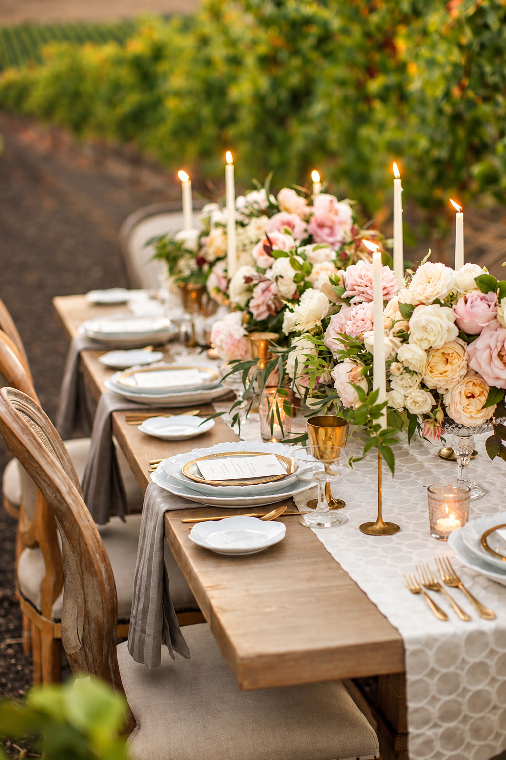 Candlelit outdoor wedding table decorated with pink and white flowers