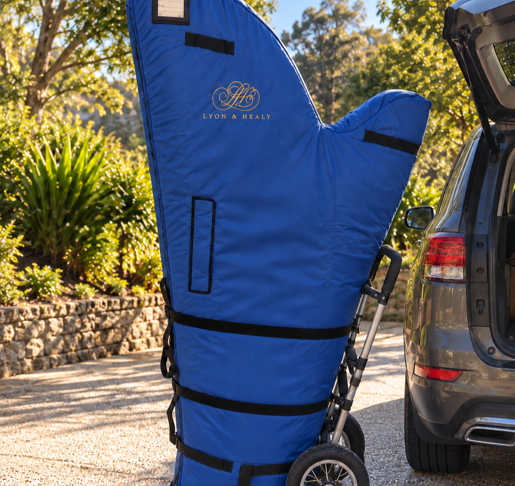 Blue Lyon & Healy harp transport cover beside an open car outdoors