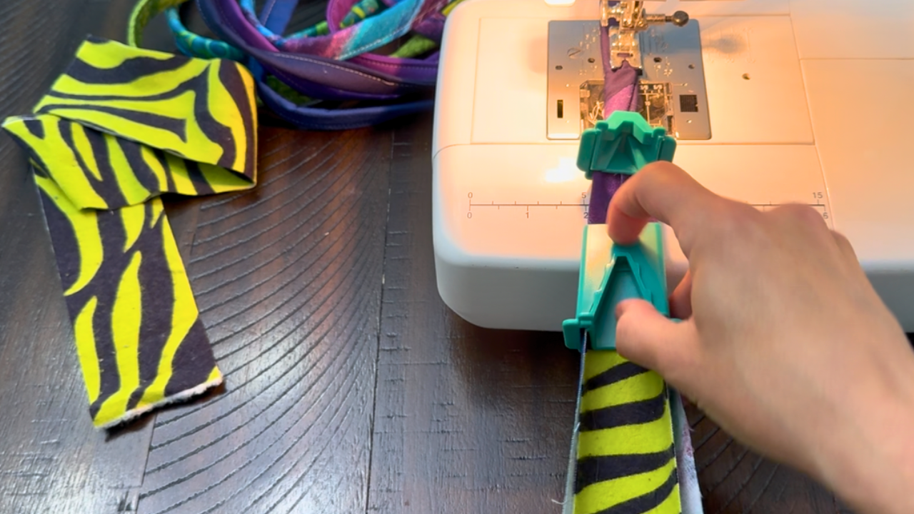 close up of flannel batting going through the clover tube maker to sew