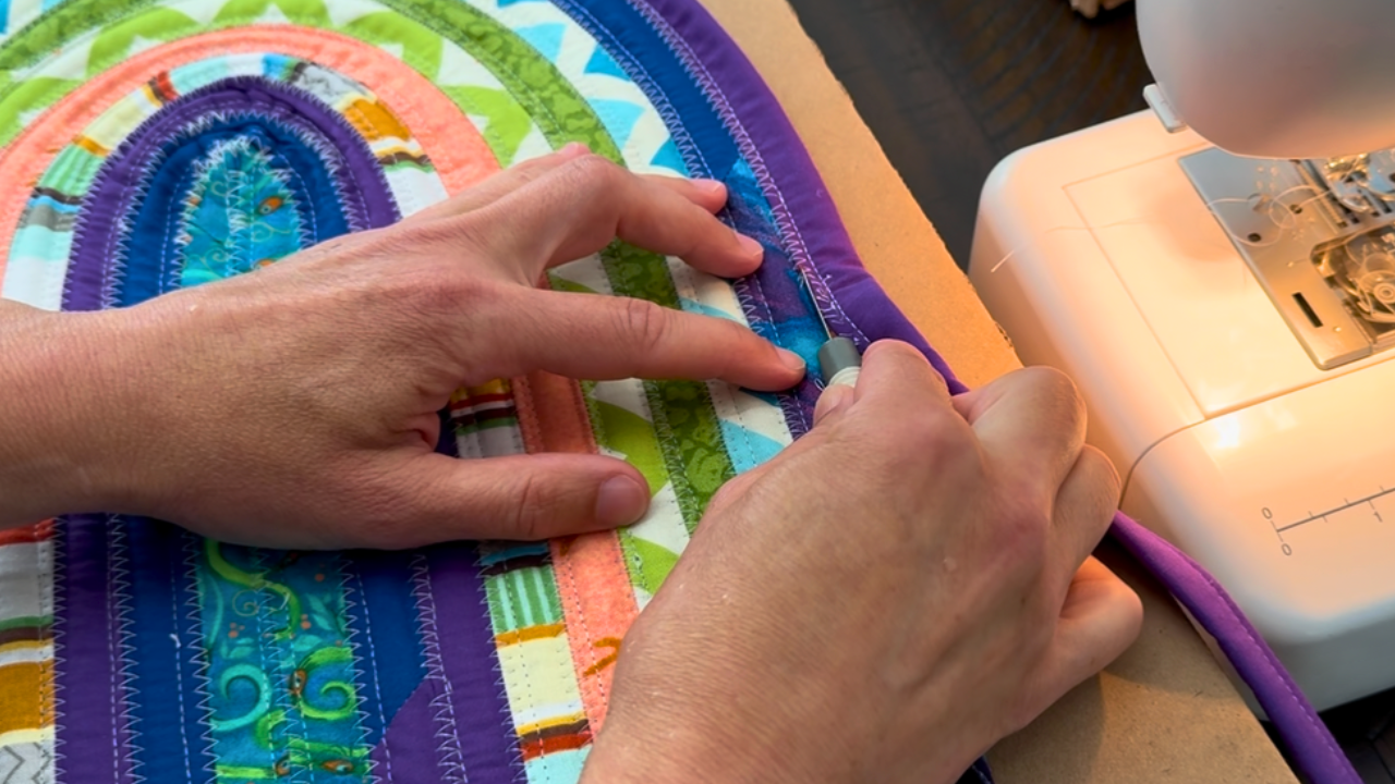 using a seam ripper to try and fix the wave in a jelly roll rug