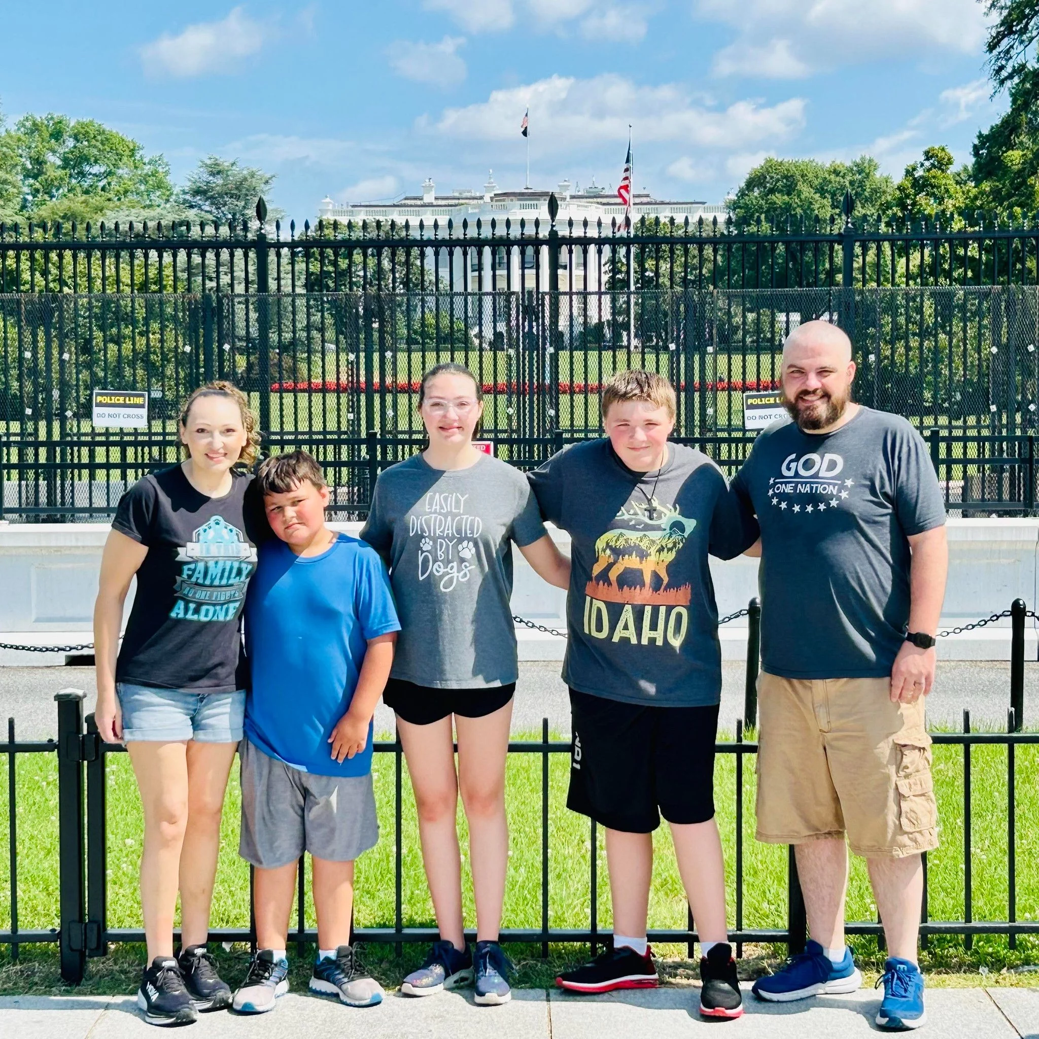 Youth director and family at the U.S. Capitol building on a sunny day with trees and a blue sky in the background.