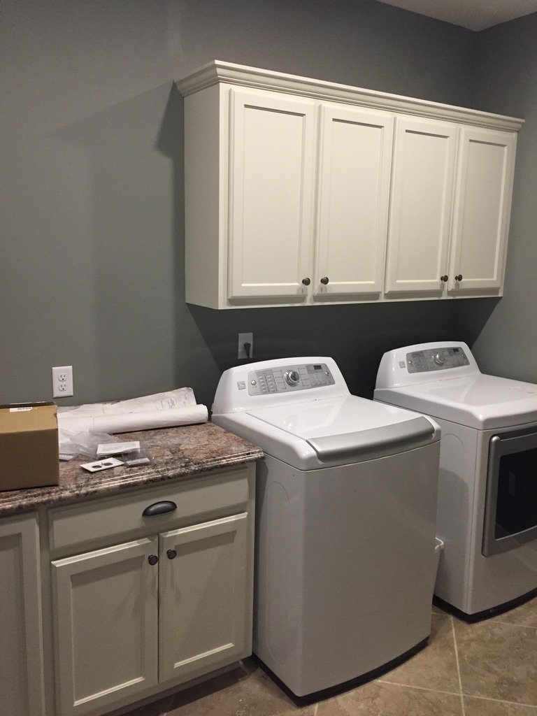 Laundry room with white cabinets, a granite countertop, and a washing machine and dryer.