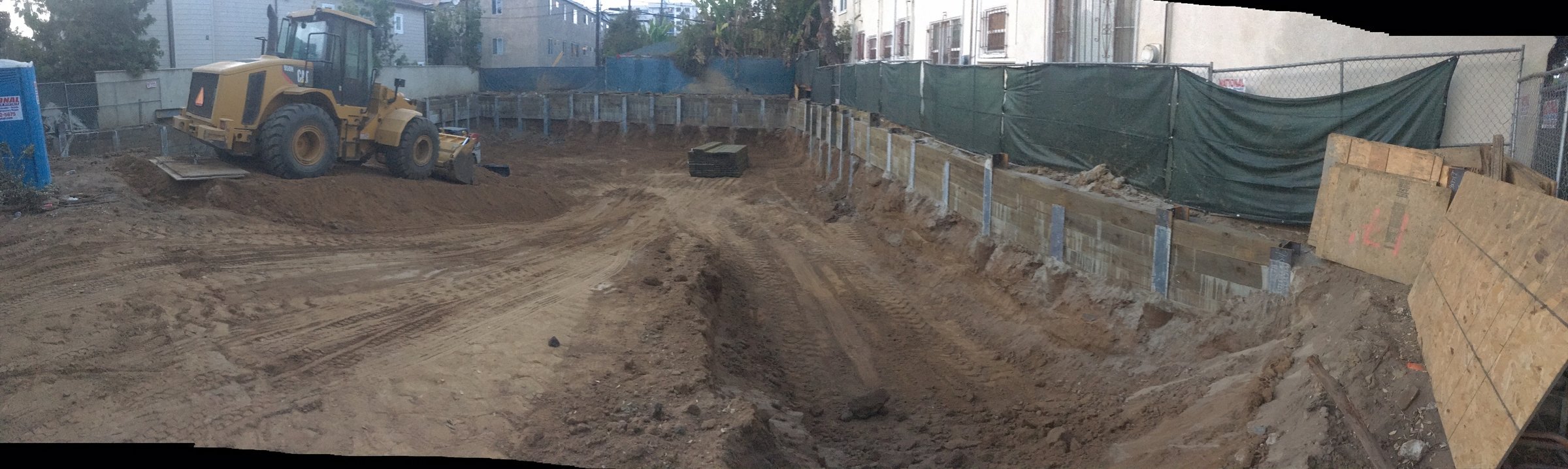 [new-construction] Panoramic view of a shored basement excavation across a Santa Monica building site