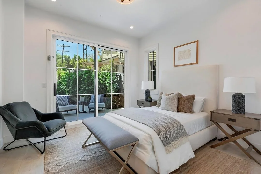 [adu-construction] Guest bedroom with sliding doors to a private patio and treetop views in a Cheviot Hills custom home