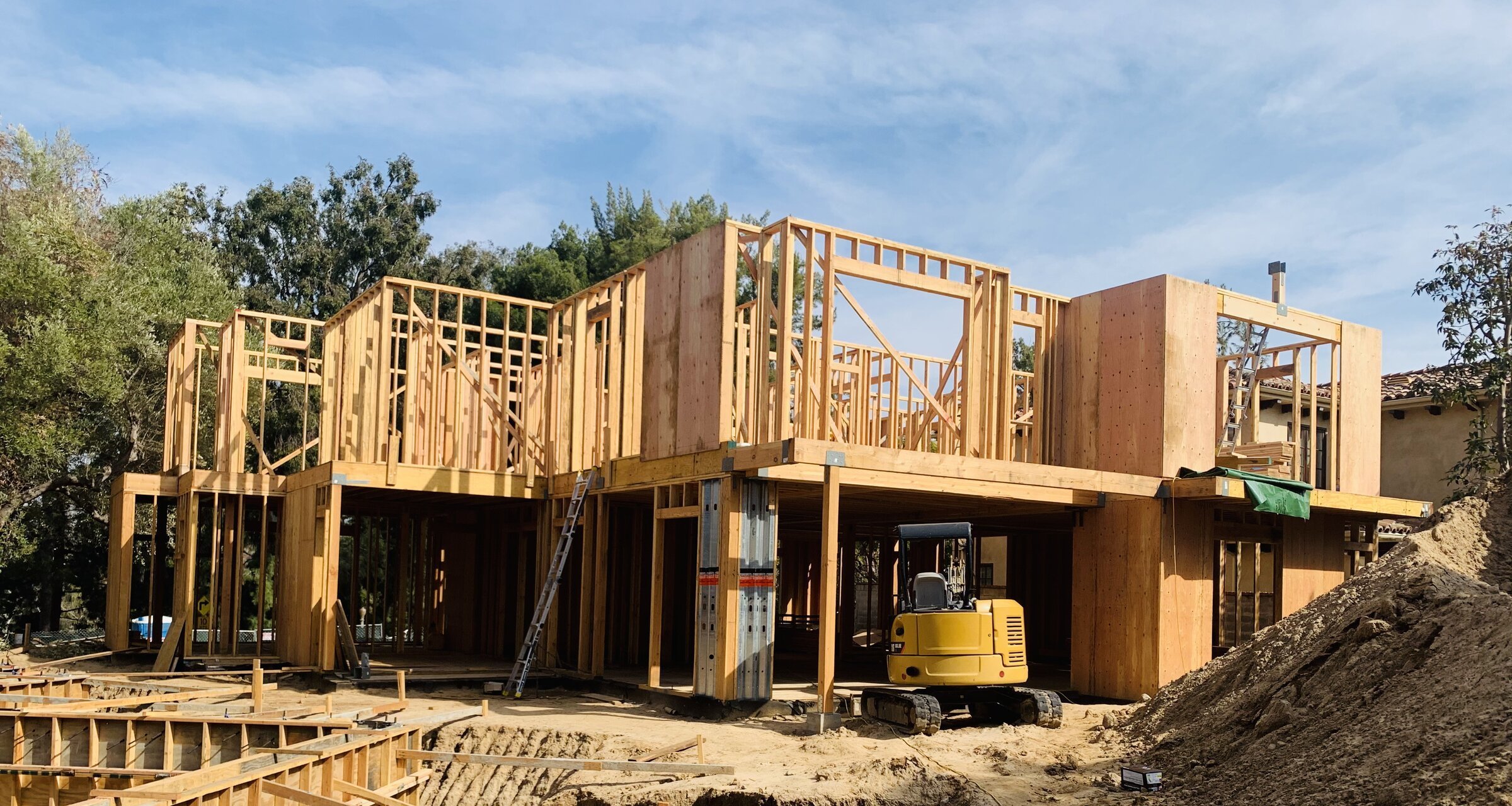 [new-construction] Two-story wood framing rising over a concrete basement on a Los Angeles custom home
