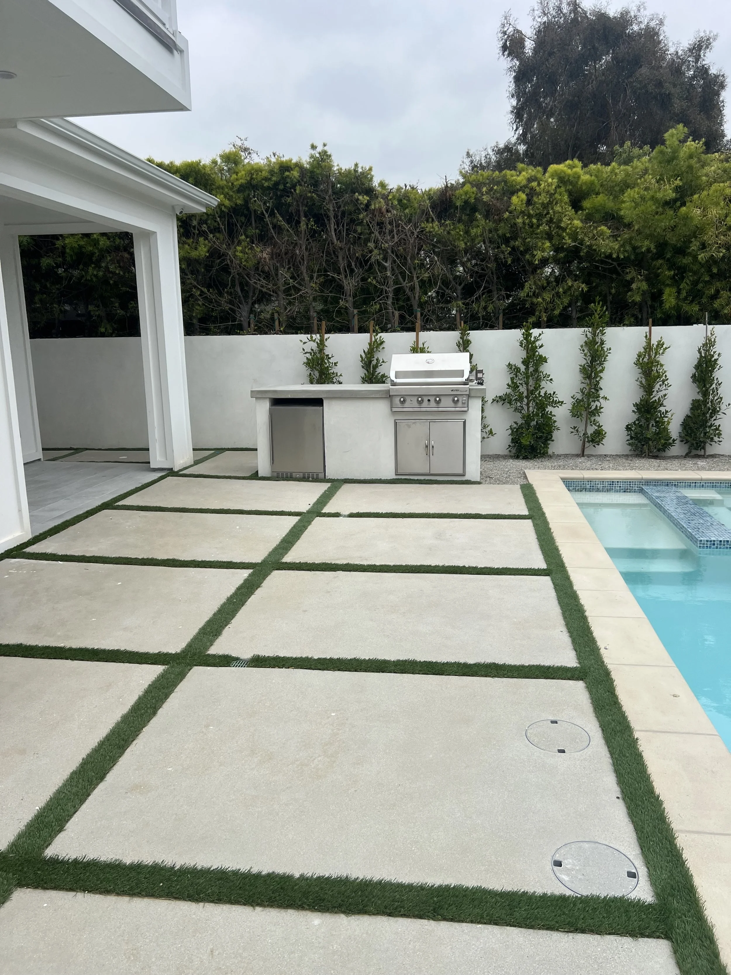 [hardscaping] Backyard pool and spa with a paver-and-turf deck and a stainless built-in barbecue island at a Rancho Park / West LA custom home
