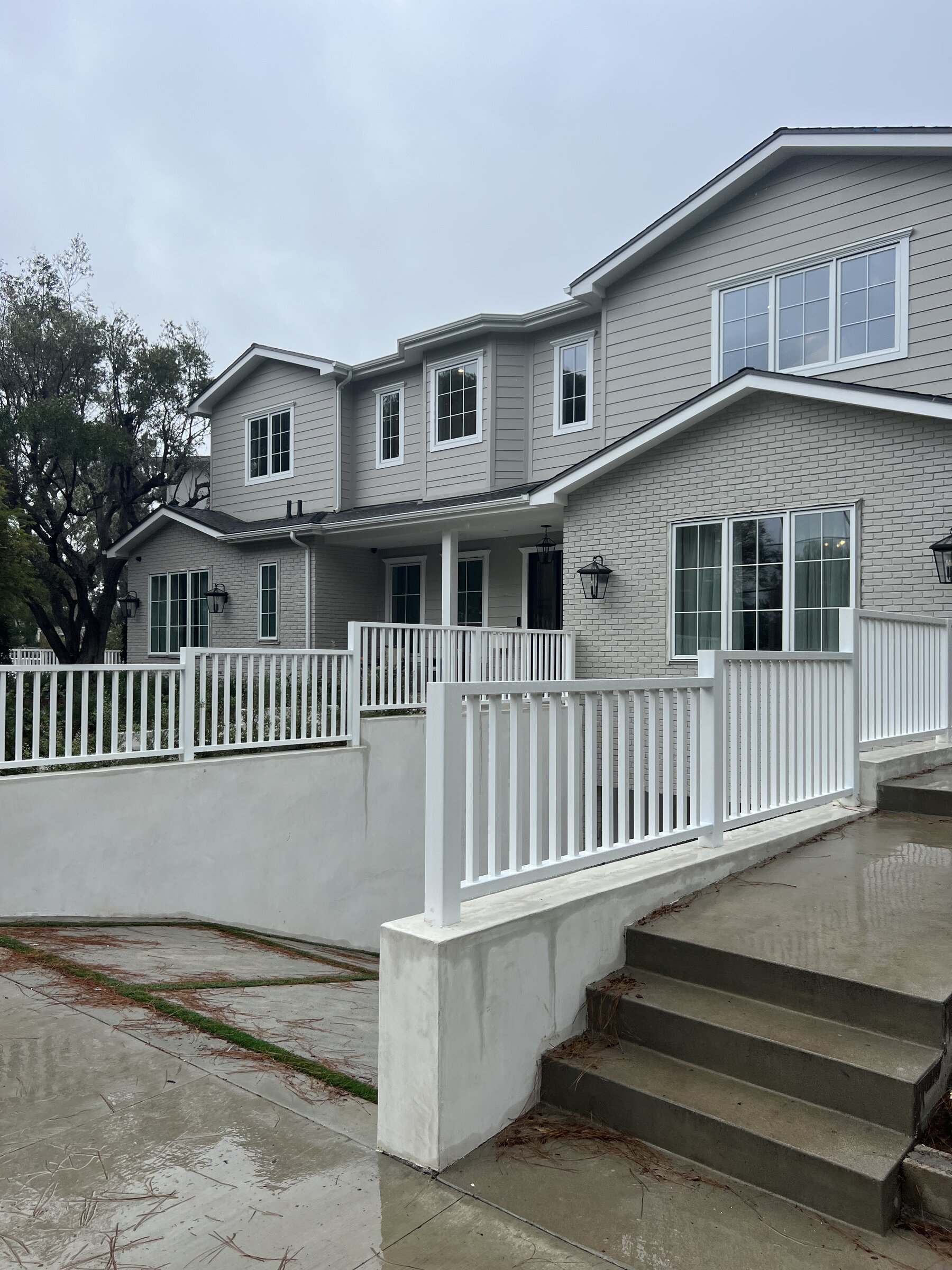 Front elevation of a new custom home with covered porch over a subterranean garage in Los Angeles
