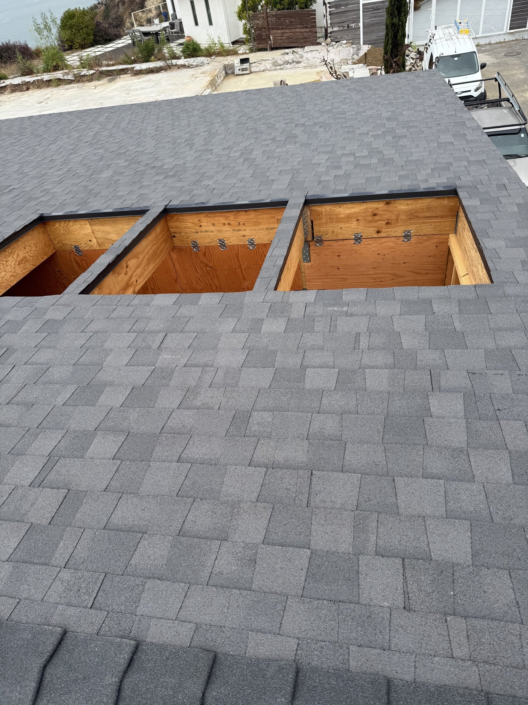 [new-construction] New composition shingle roof with framed skylight openings on a Malibu home