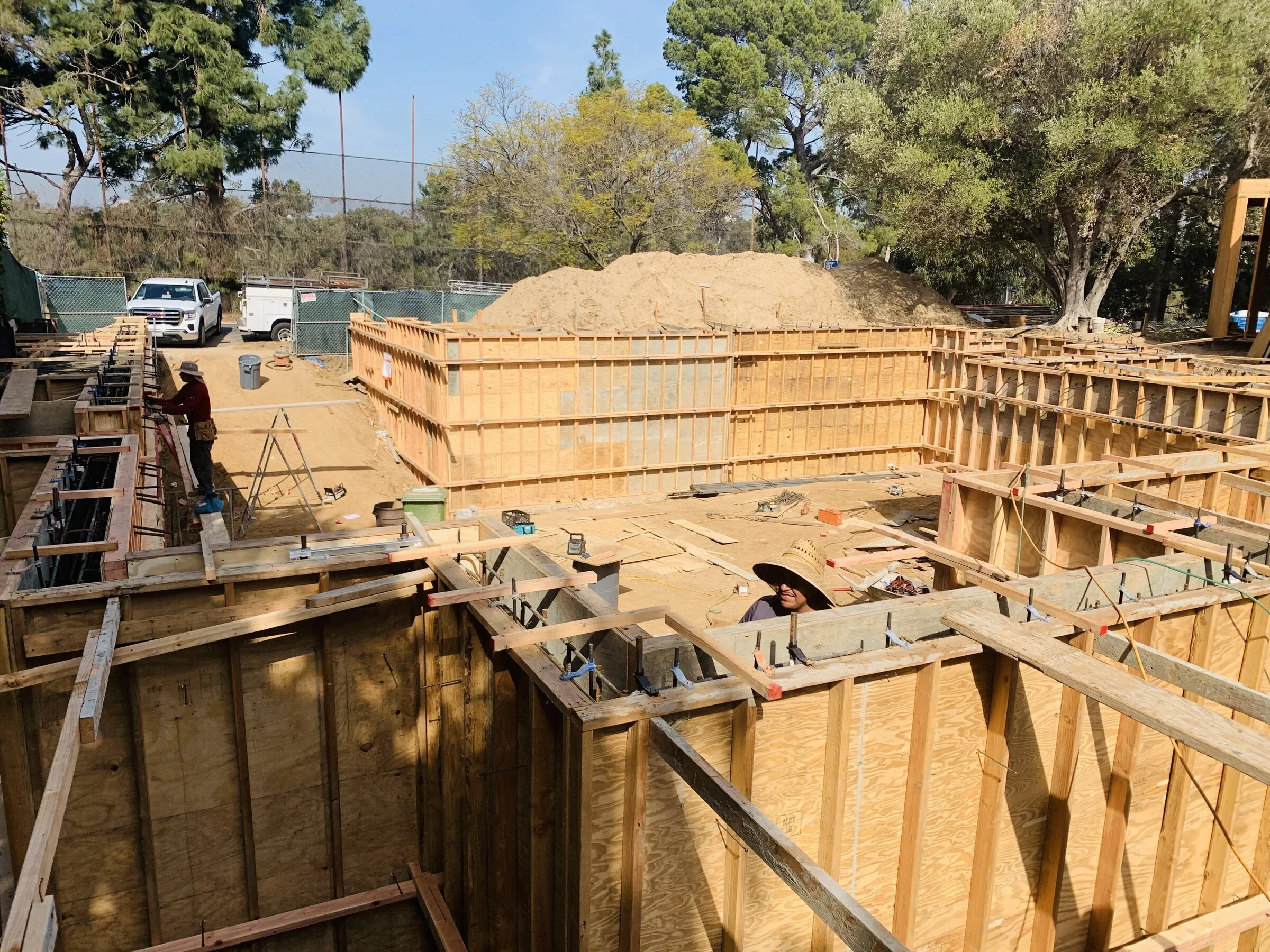 [new-construction] Carpenters building double-sided concrete wall forms for a custom home in Los Angeles