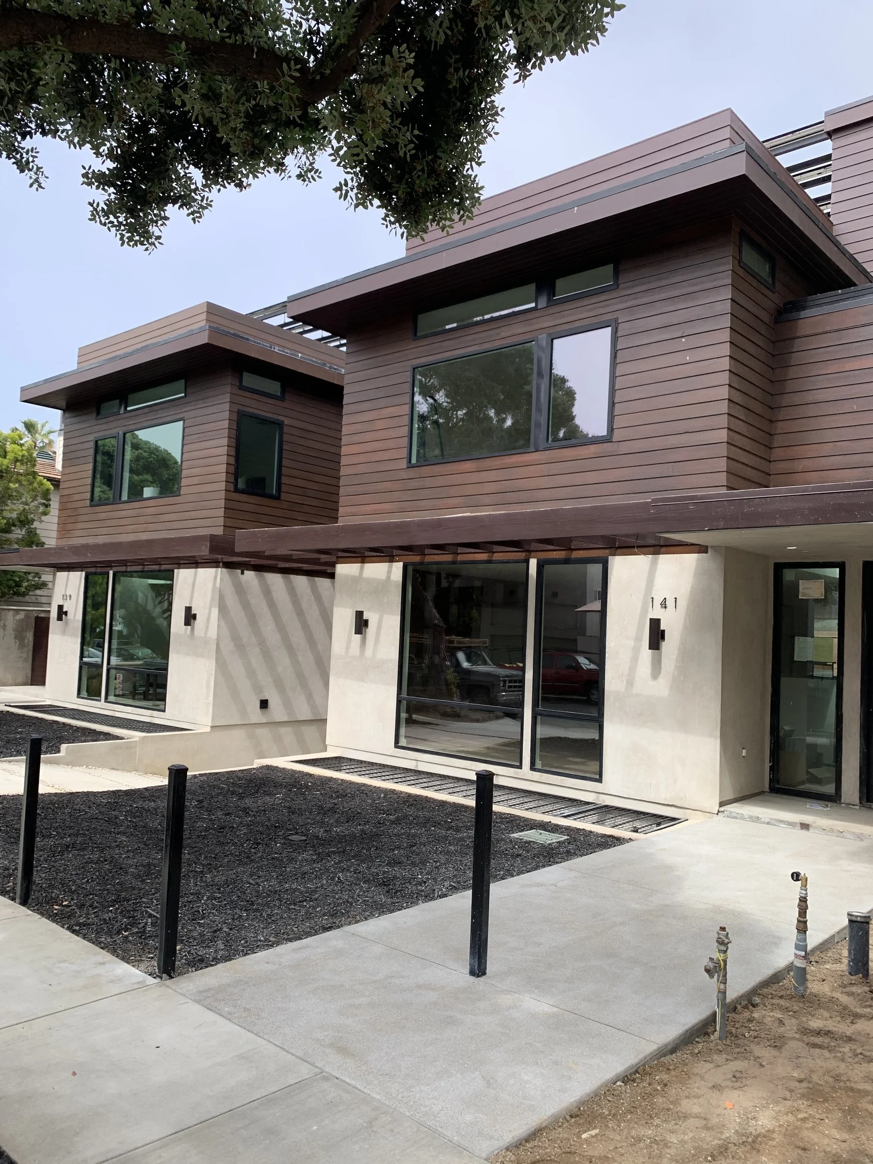 Two finished modern custom homes with wood siding and pergolas in Santa Monica