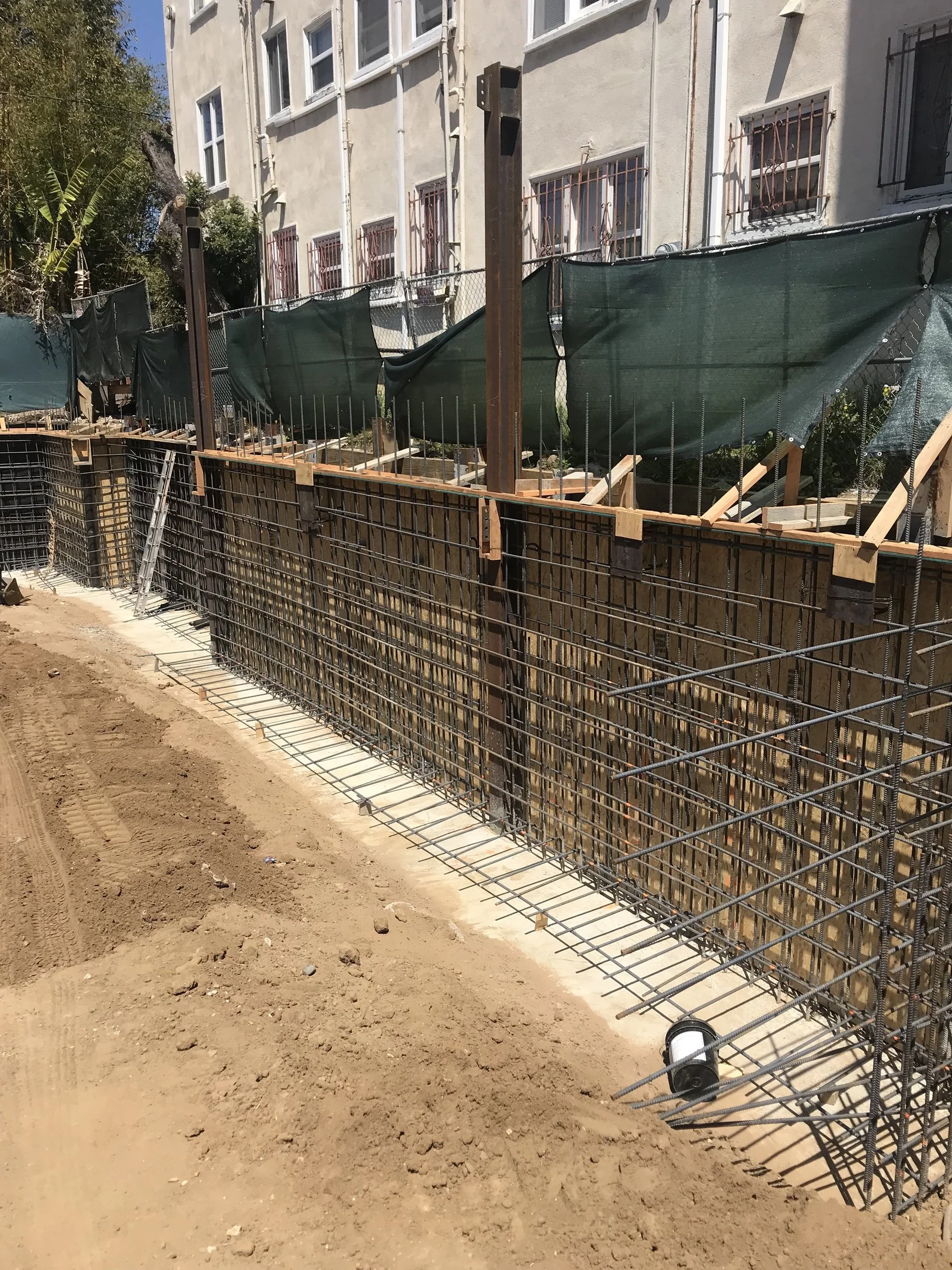 [new-construction] Two-sided reinforcing-steel cage for a basement retaining wall along timber shoring in Santa Monica
