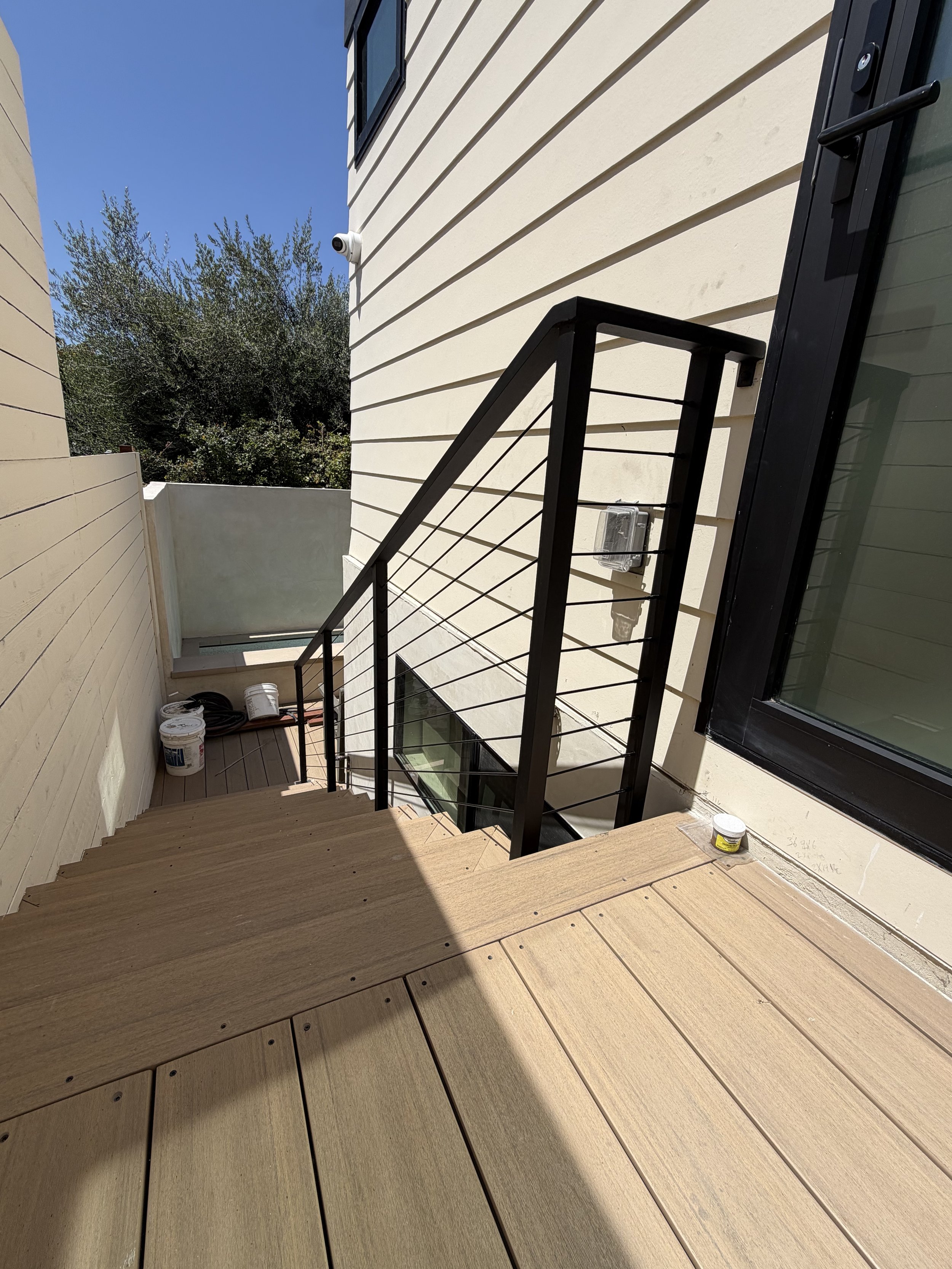 [hardscaping] Composite stair landing with cable railing under construction in a Santa Monica home