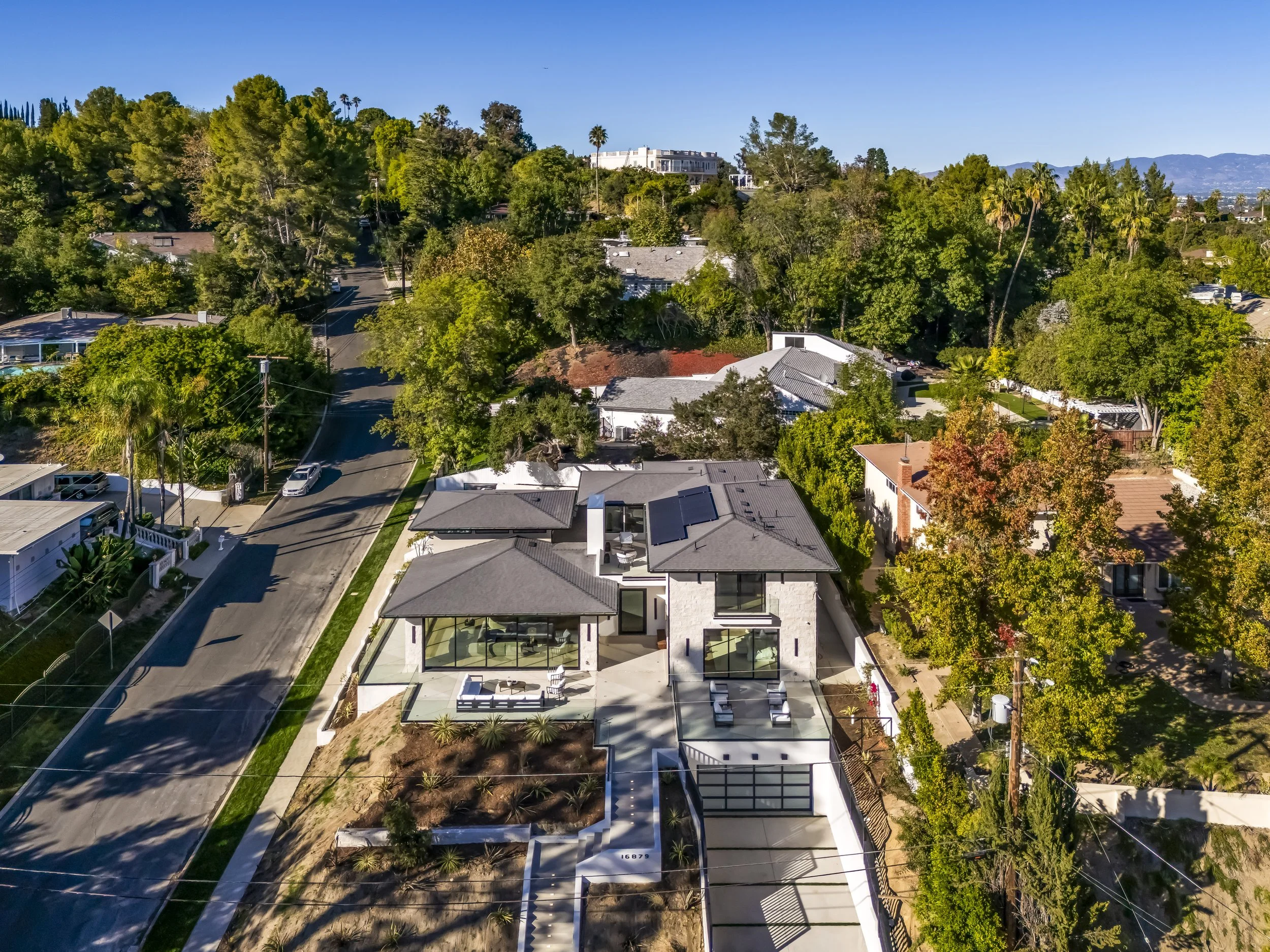 Aerial view of a newly built modern home on a hillside lot in Encino, California