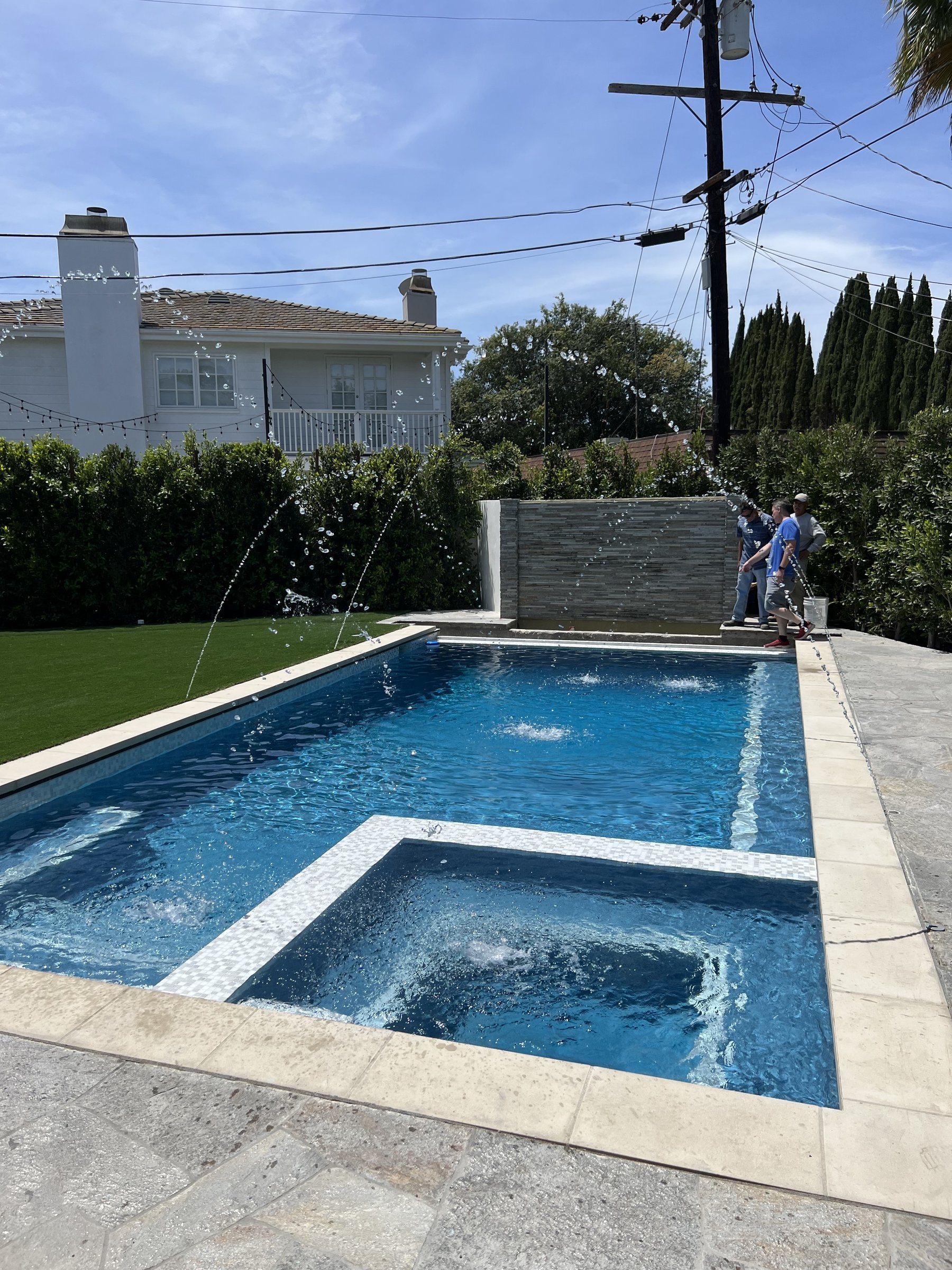 [pool-installation] Finished custom pool and raised spa with deck jets and a stone water wall running in Los Angeles