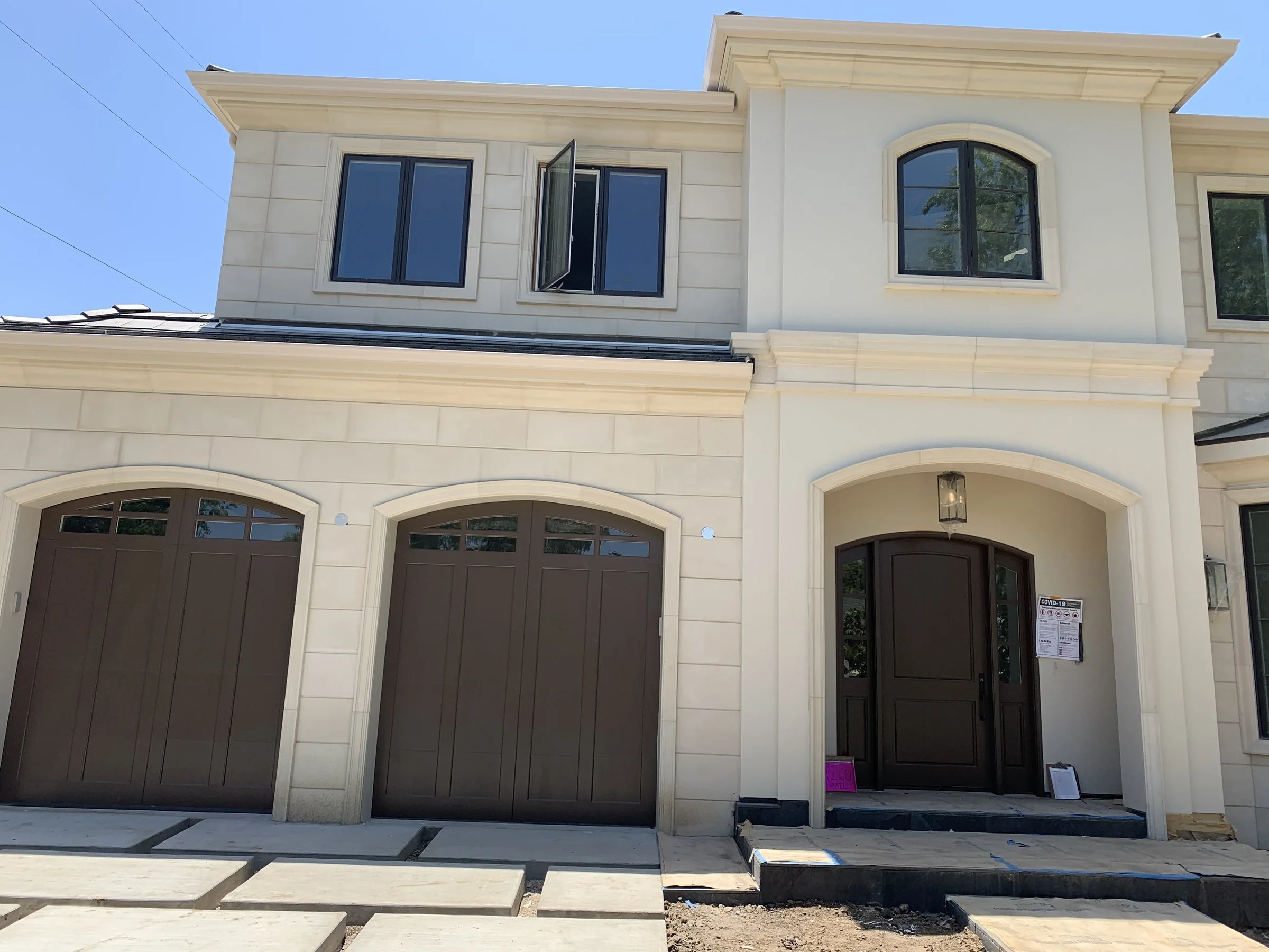 Finished traditional custom home with a cast-stone facade and arched wood doors in Los Angeles