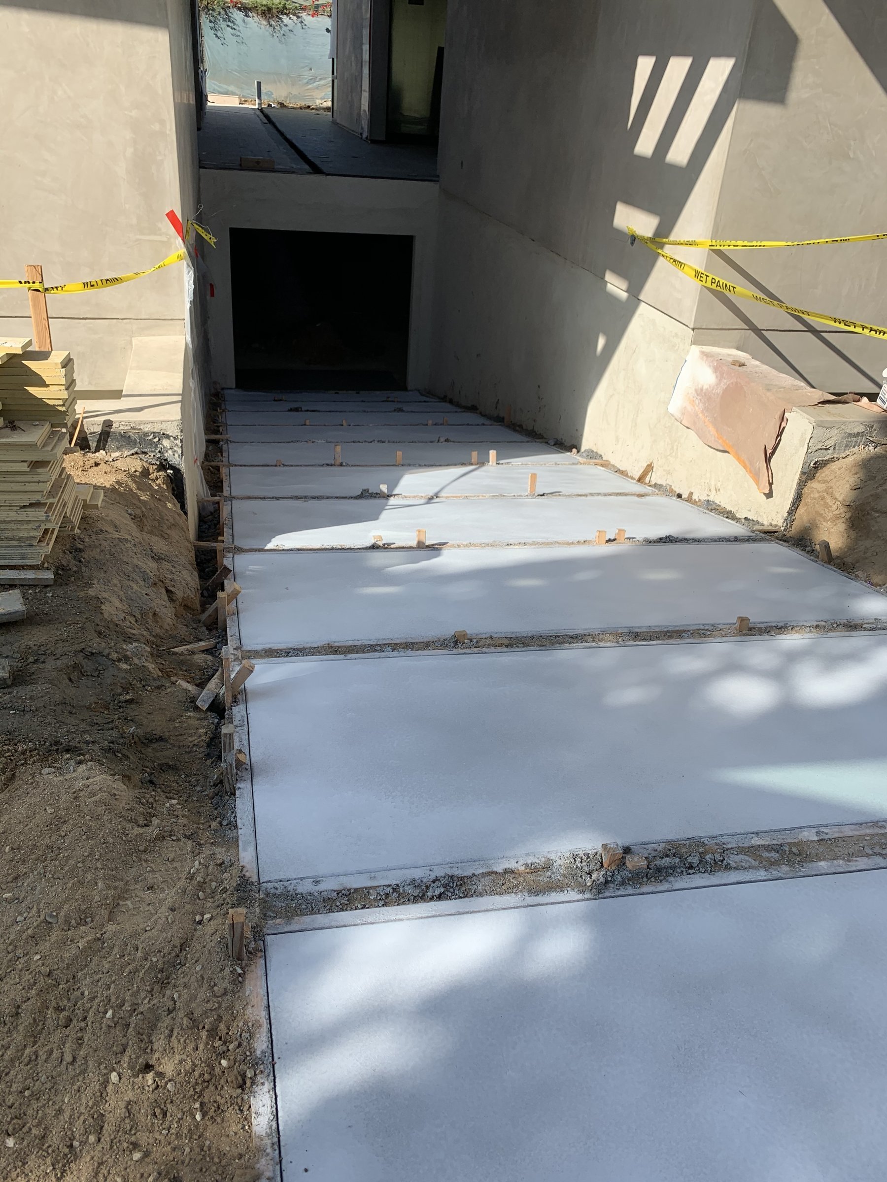 [hardscaping] Poured concrete pathway with formwork alongside a Santa Monica new build