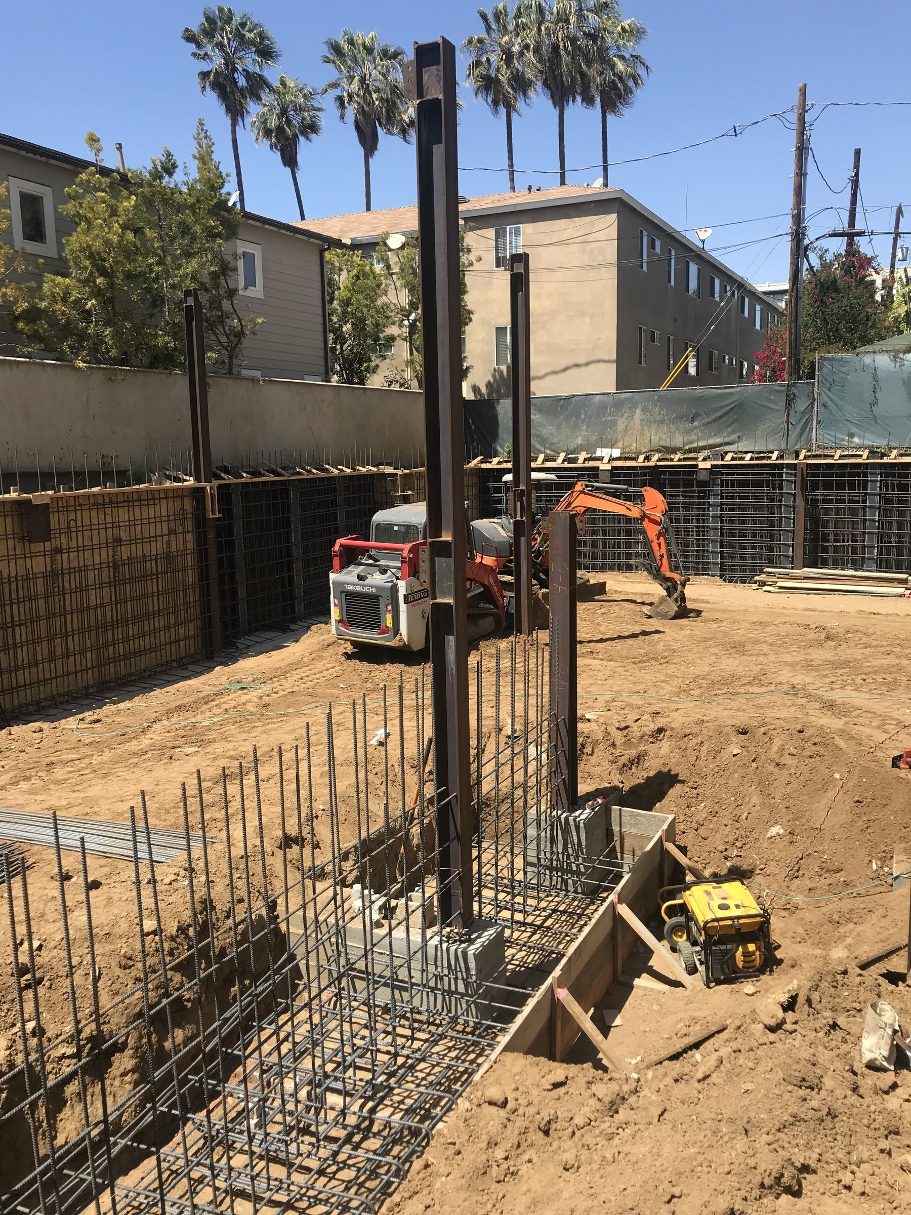 [new-construction] Hand-tied rebar cage set in a foundation grade-beam trench on a Santa Monica new build