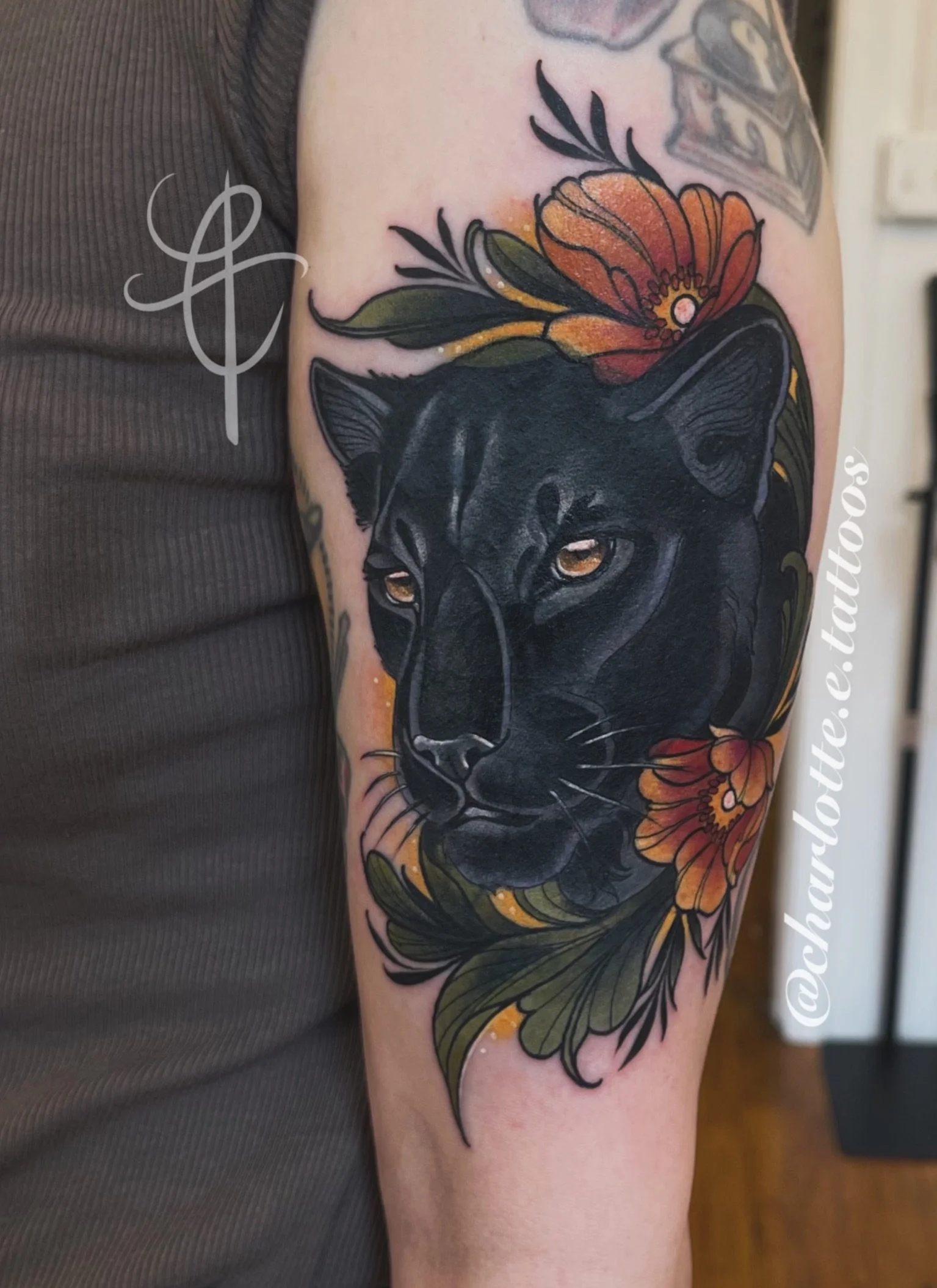 Neo-traditional black panther upper arm tattoo with florals. Made by Charlotte Timmons. 