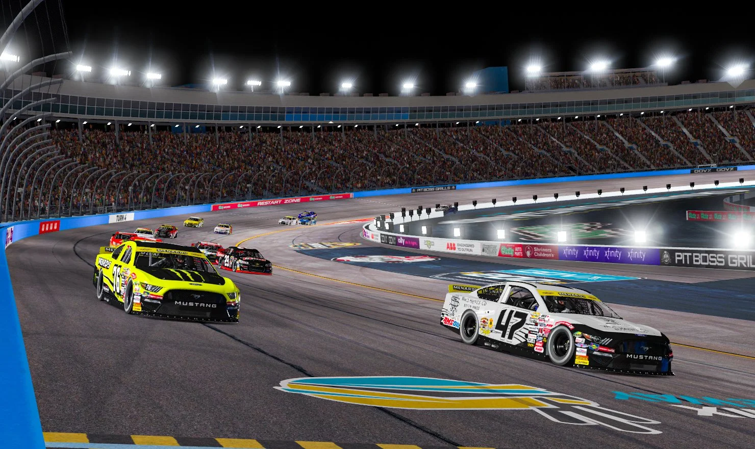 Nighttime NASCAR race with multiple race cars on the track, the front cars are white and black and yellow, racing in a curve with bright stadium lights and a large crowd in the stands.