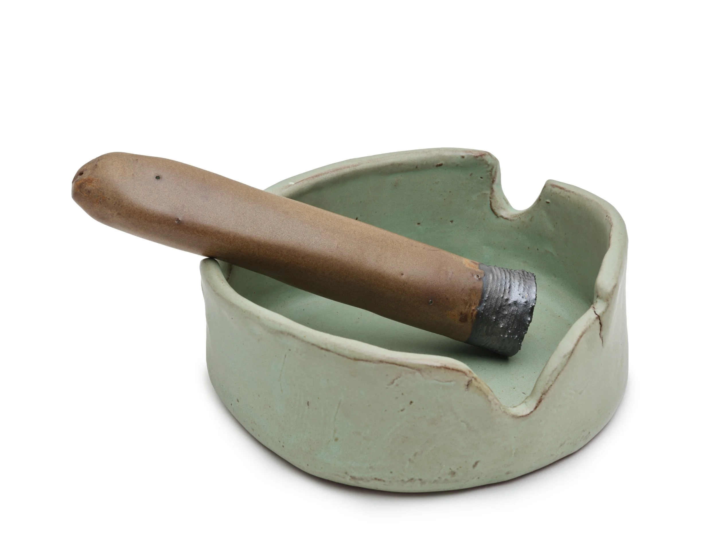 A ceramic ashtray with a cigarette resting inside, showing a burnt tip and gray ash, with a white background.