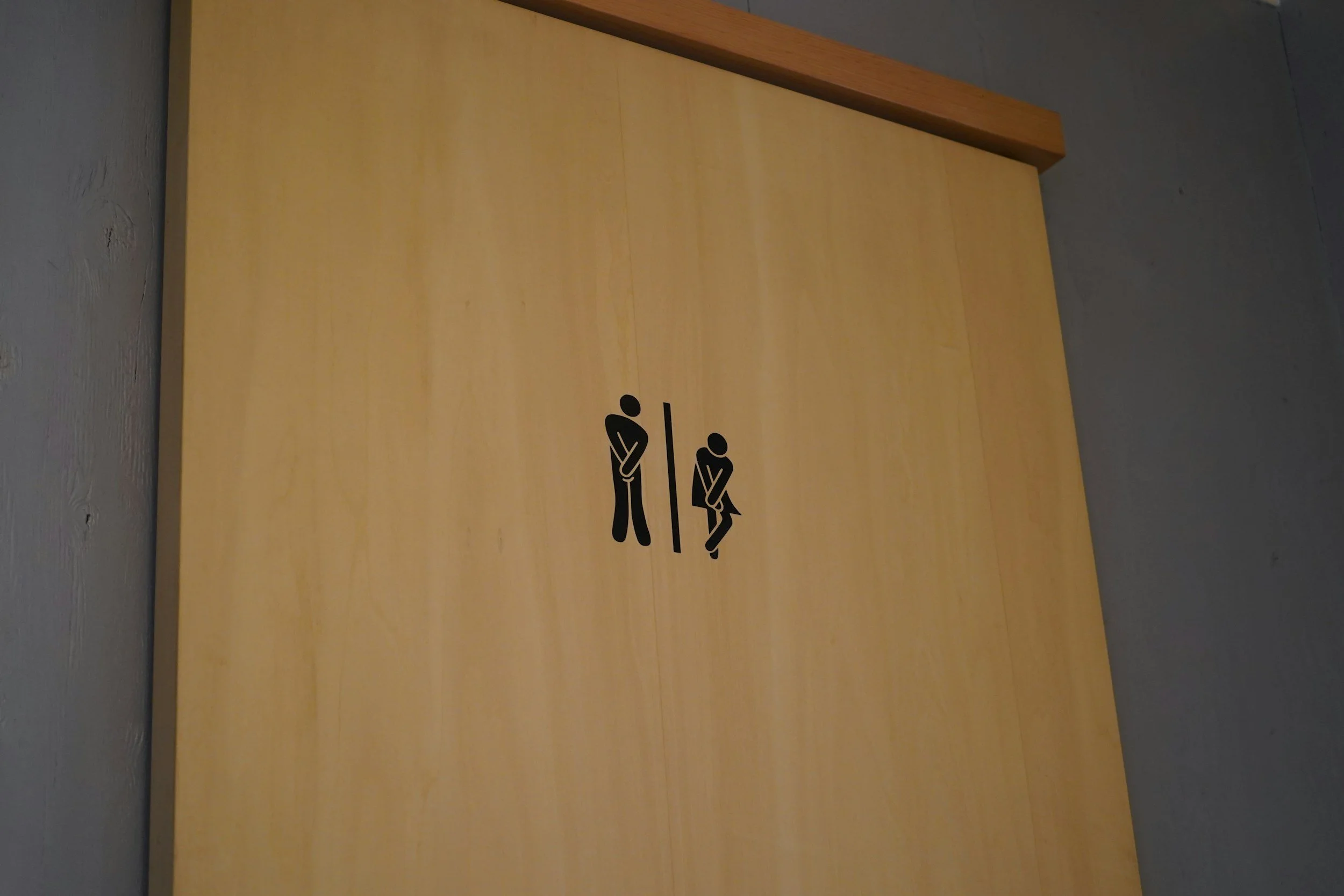 restroom sign with icons displaying urgency