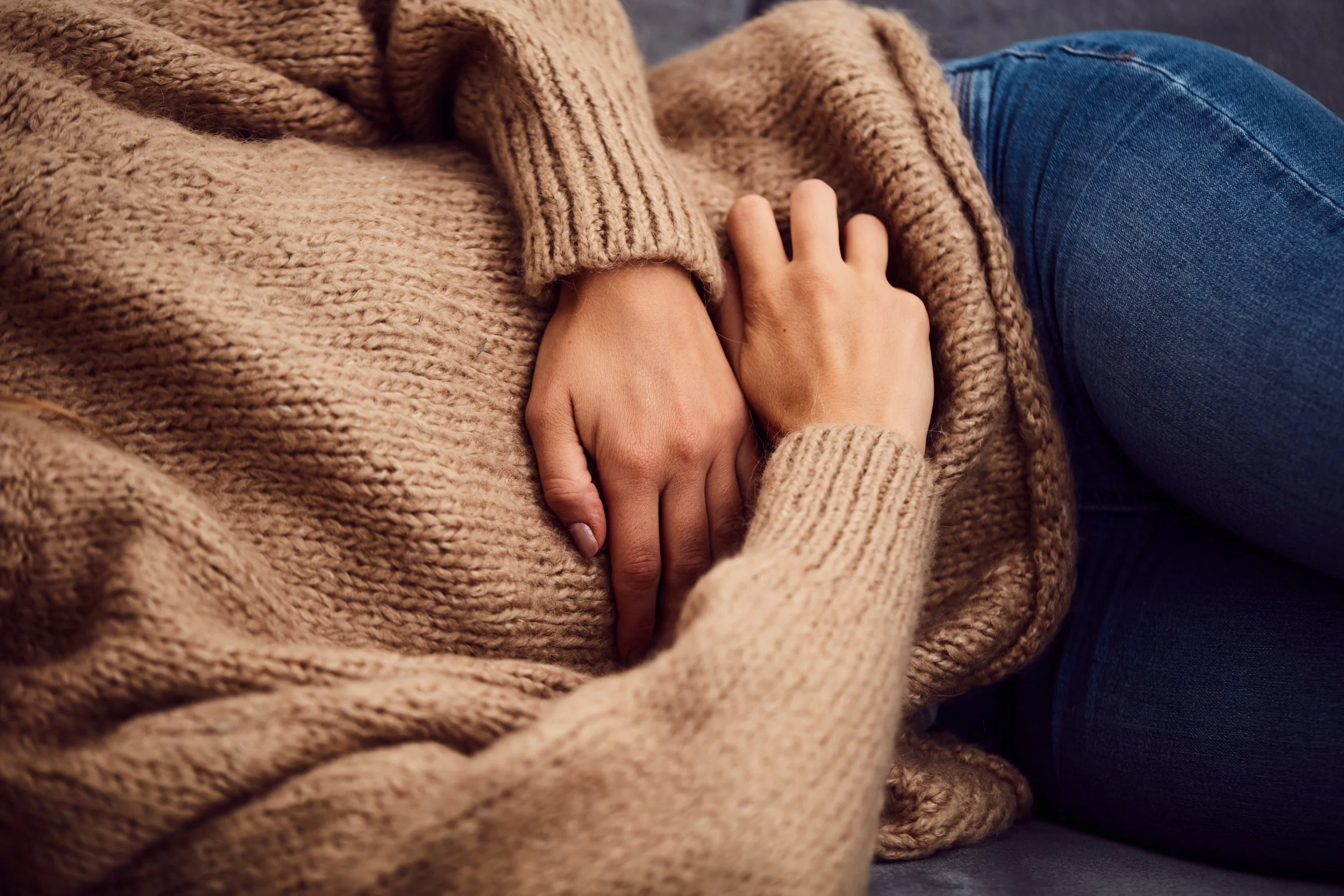 Woman clutches her abdomen in discomfort