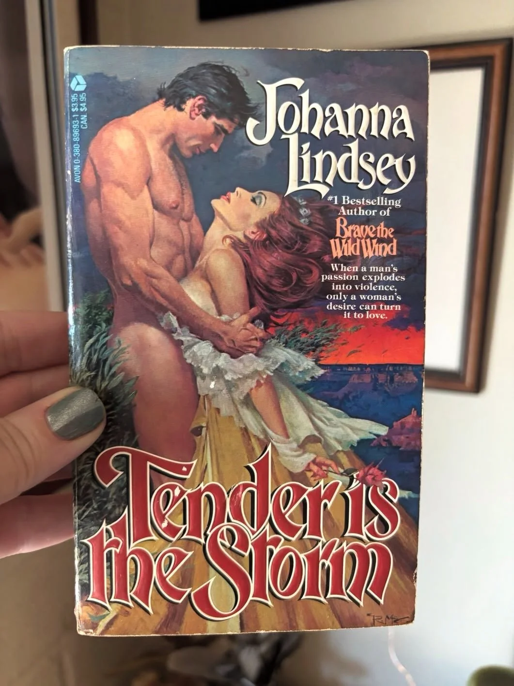 Clinch cover for Tender is the Storm by Johanna Lindsey, where a naked man clutches the arms of a woman with her breasts pushed into his stomach.