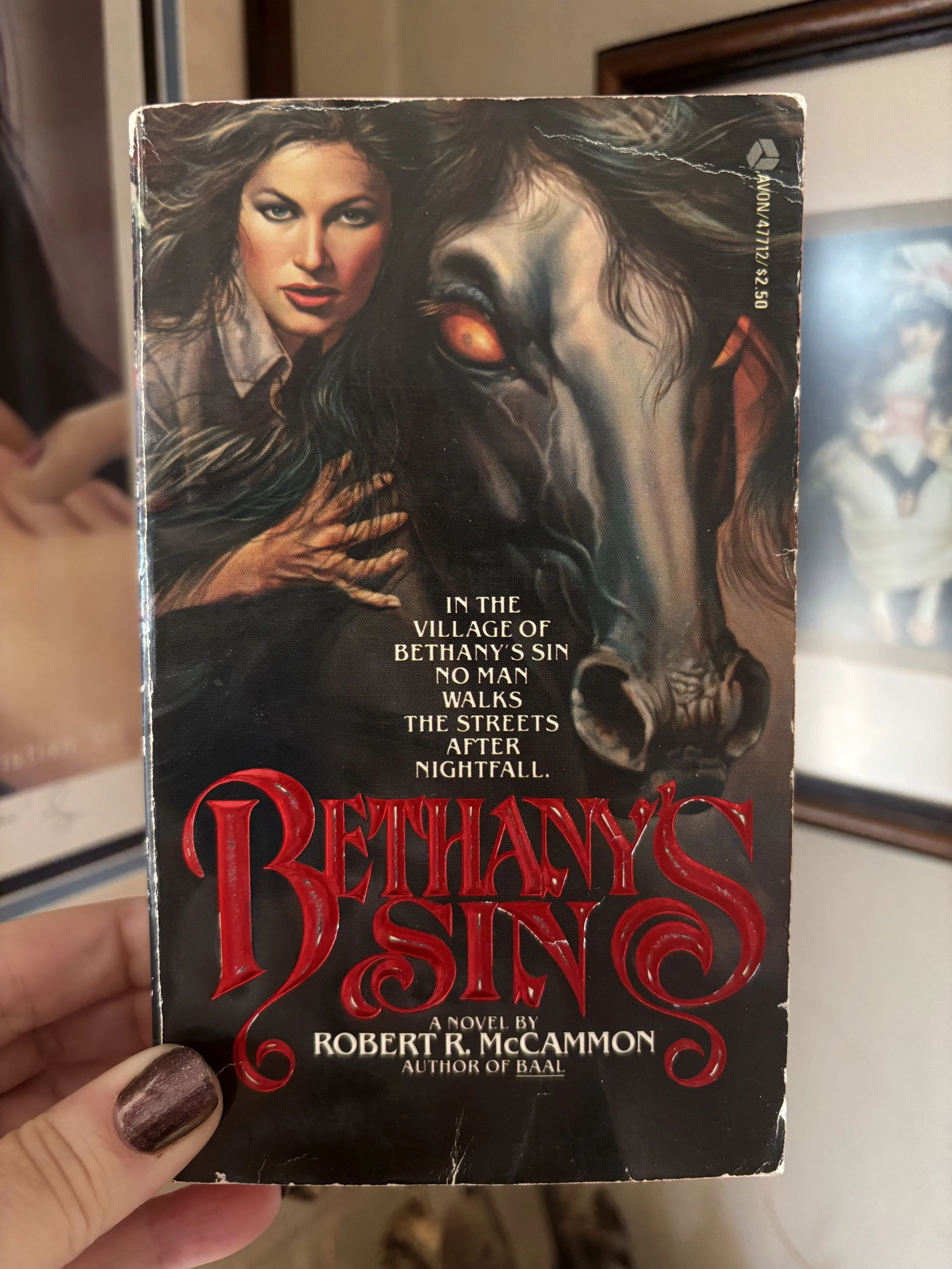 Close-up of a paperback novel titled 'Bethany's Sin' by Robert R. McCammon, featuring artwork of a woman and a horse's face.