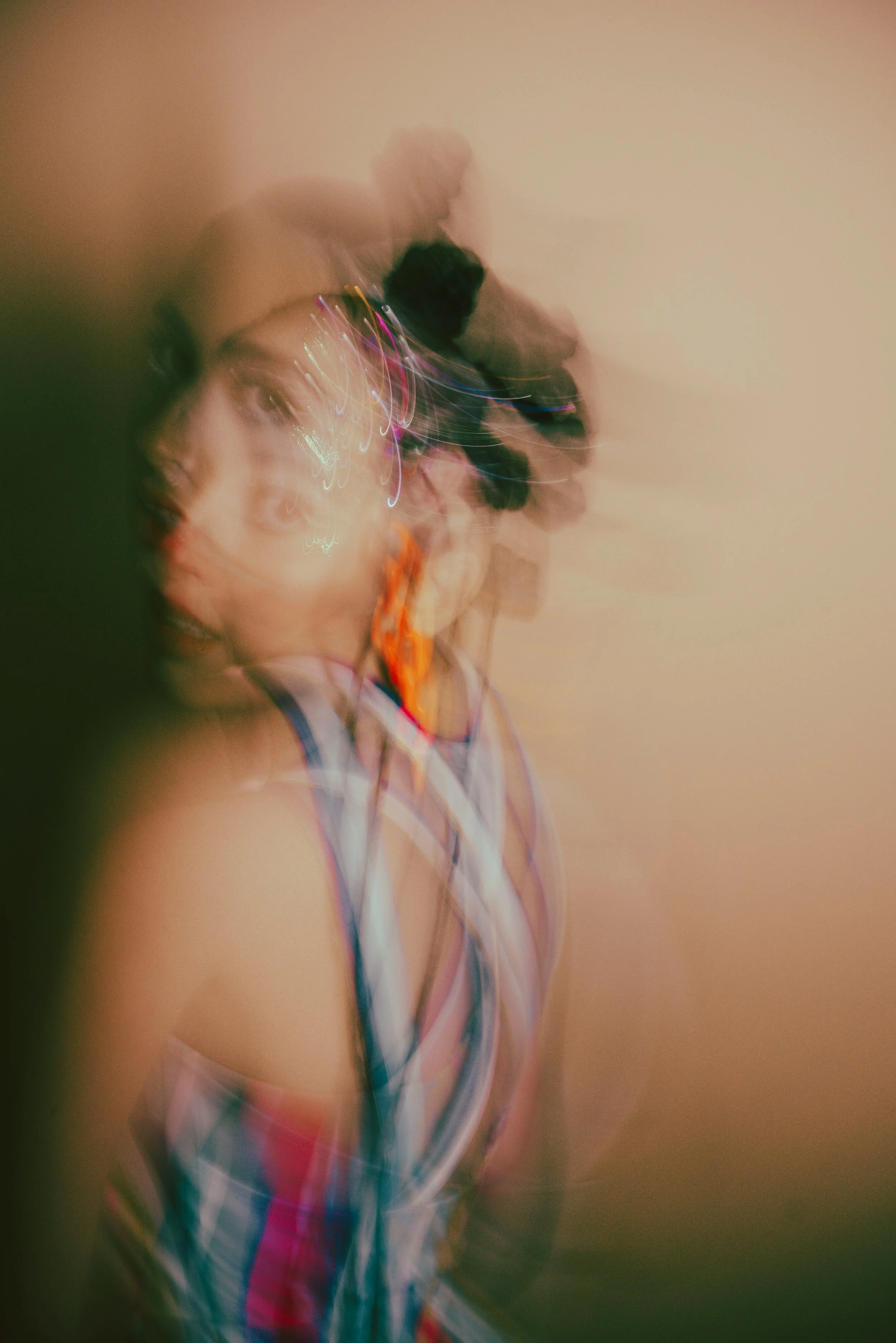 A softly blurred, layered portrait shows a person in profile, their face and colourful clothing appearing in overlapping fragments that suggest recognition still taking shape.