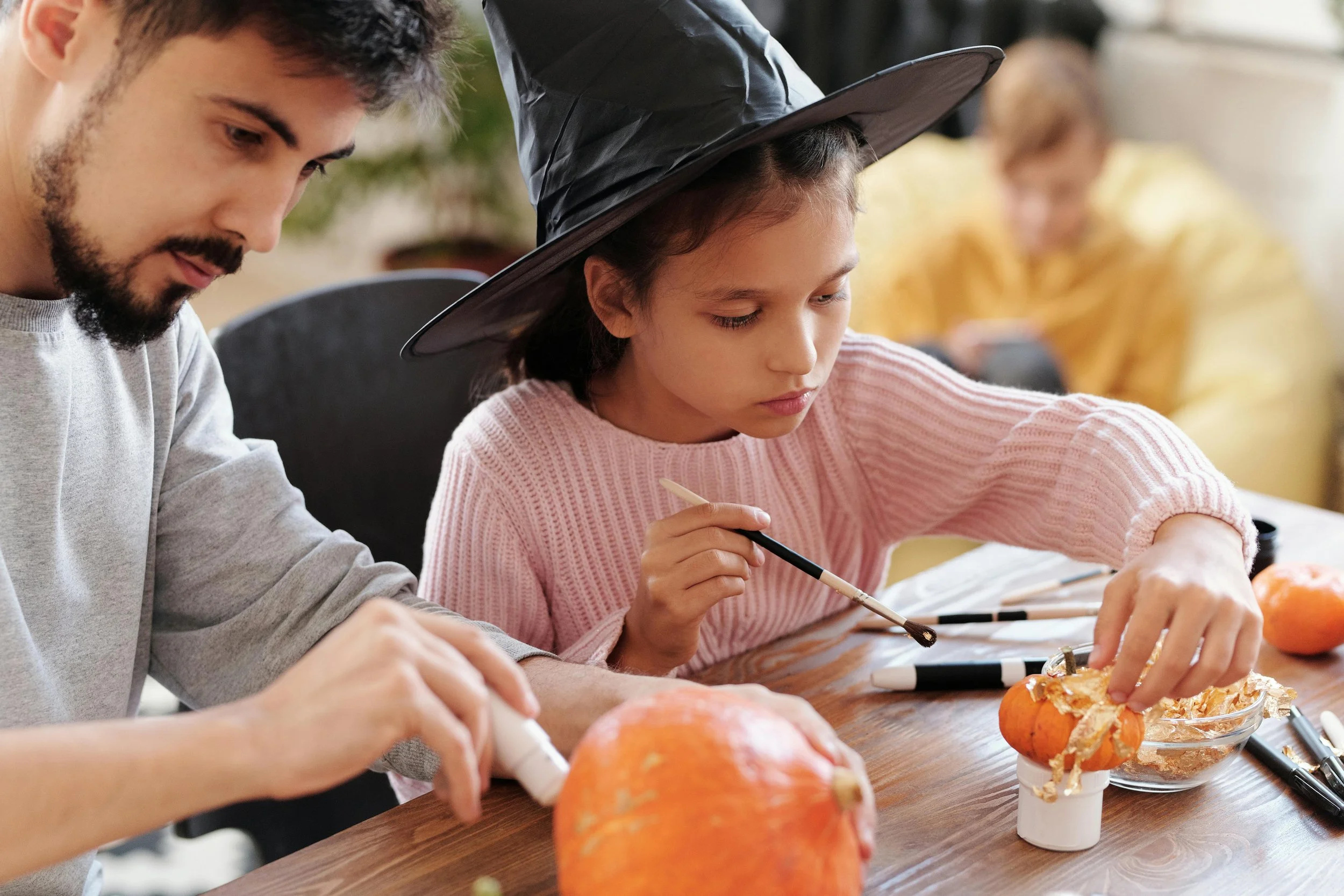 A child and parent doing fall crafts