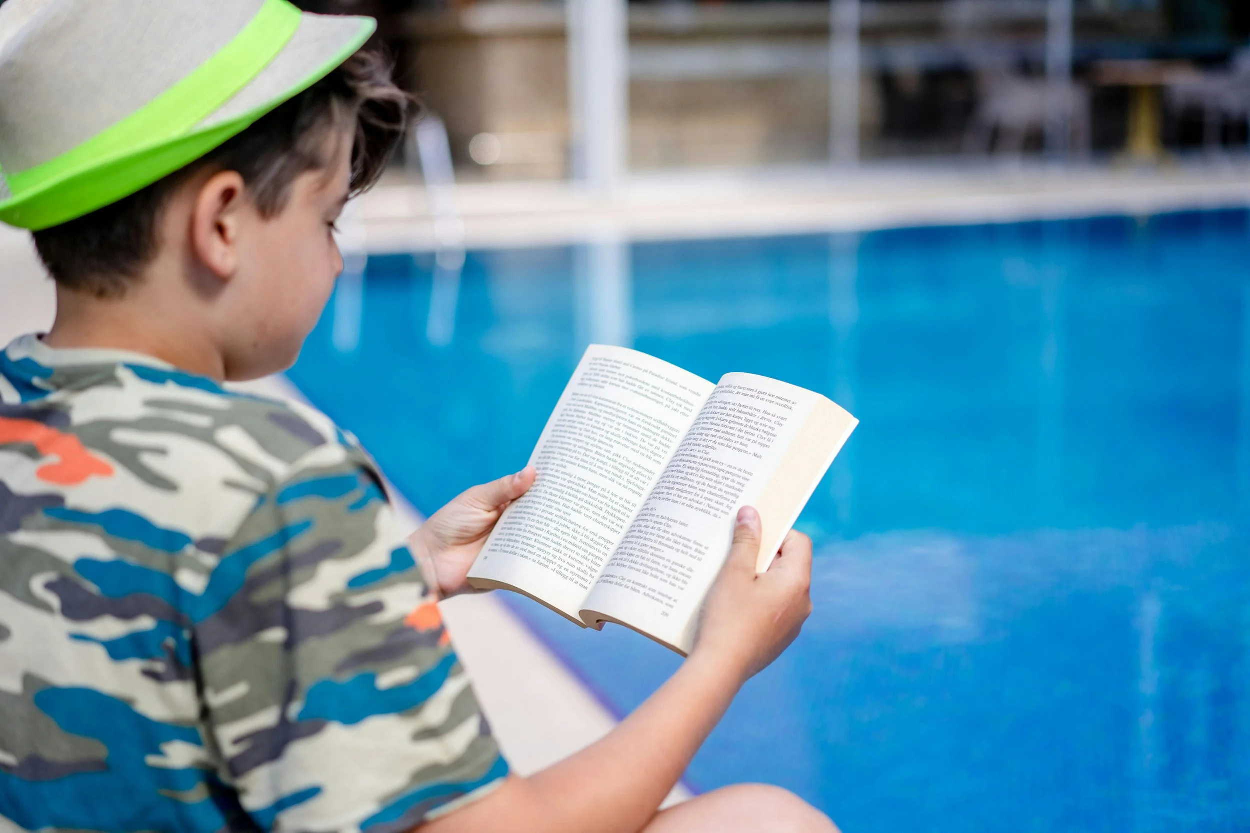 A child reading pool-side