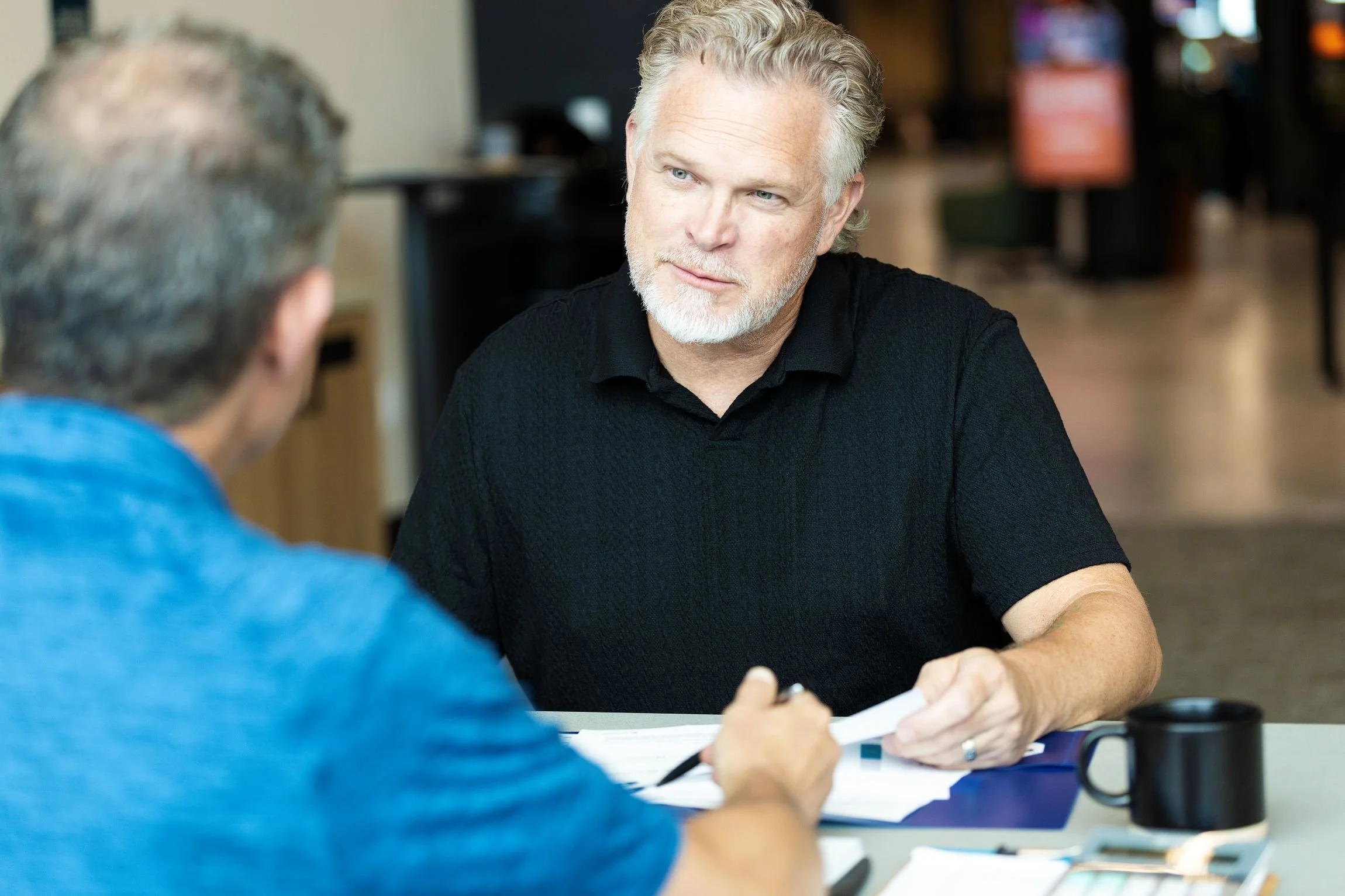 Two men at a desk having a discussion