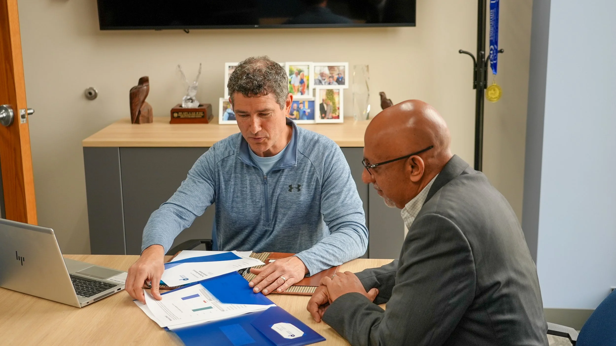 Randy Derenzo looking over paperwork with male client