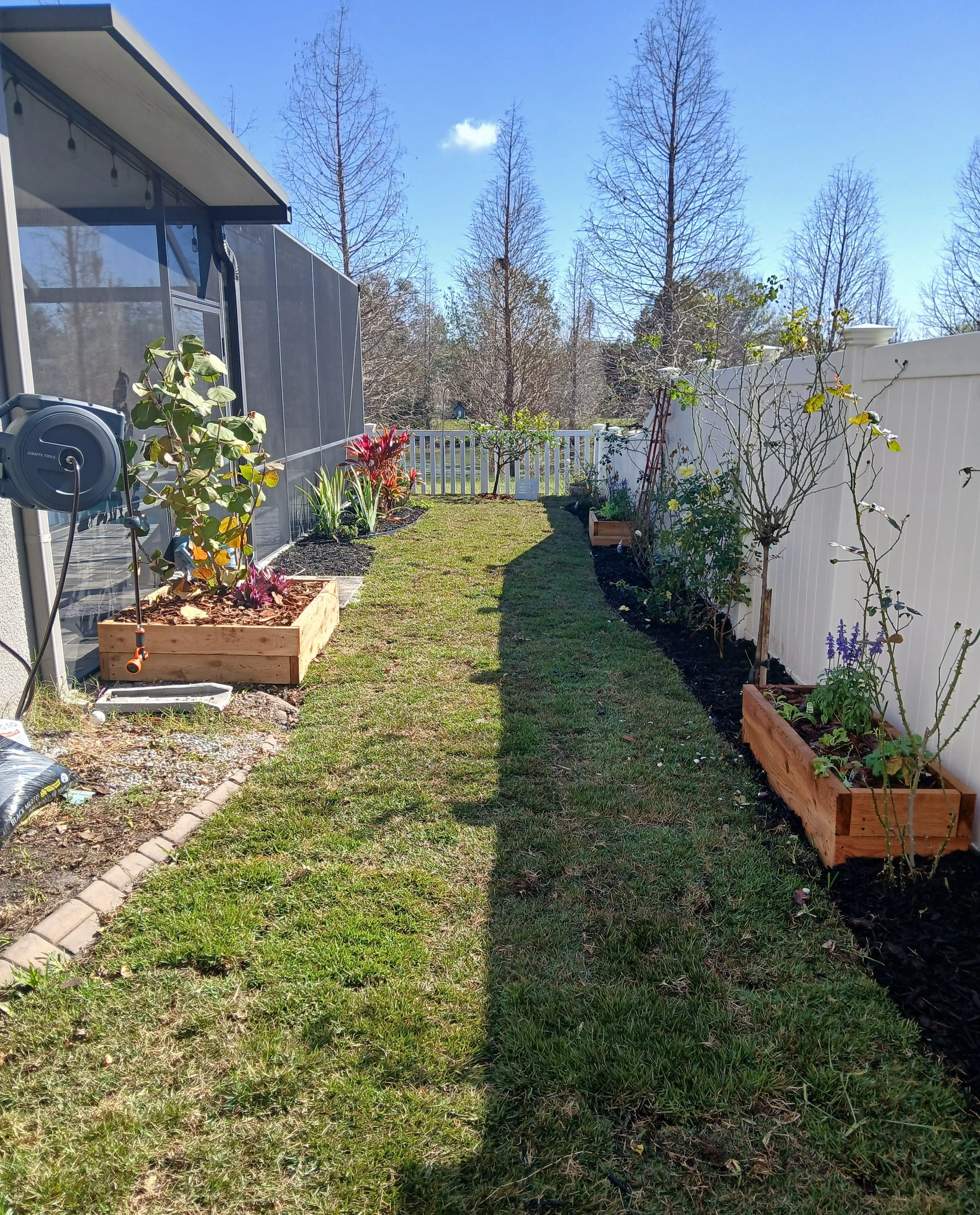 Durant, FL-Custom Cedar Raised bed installation designed to maximize the space and create intentional focal points. Rose plantings add color and character while black aluminum edging defines clean lines throughout the yard.