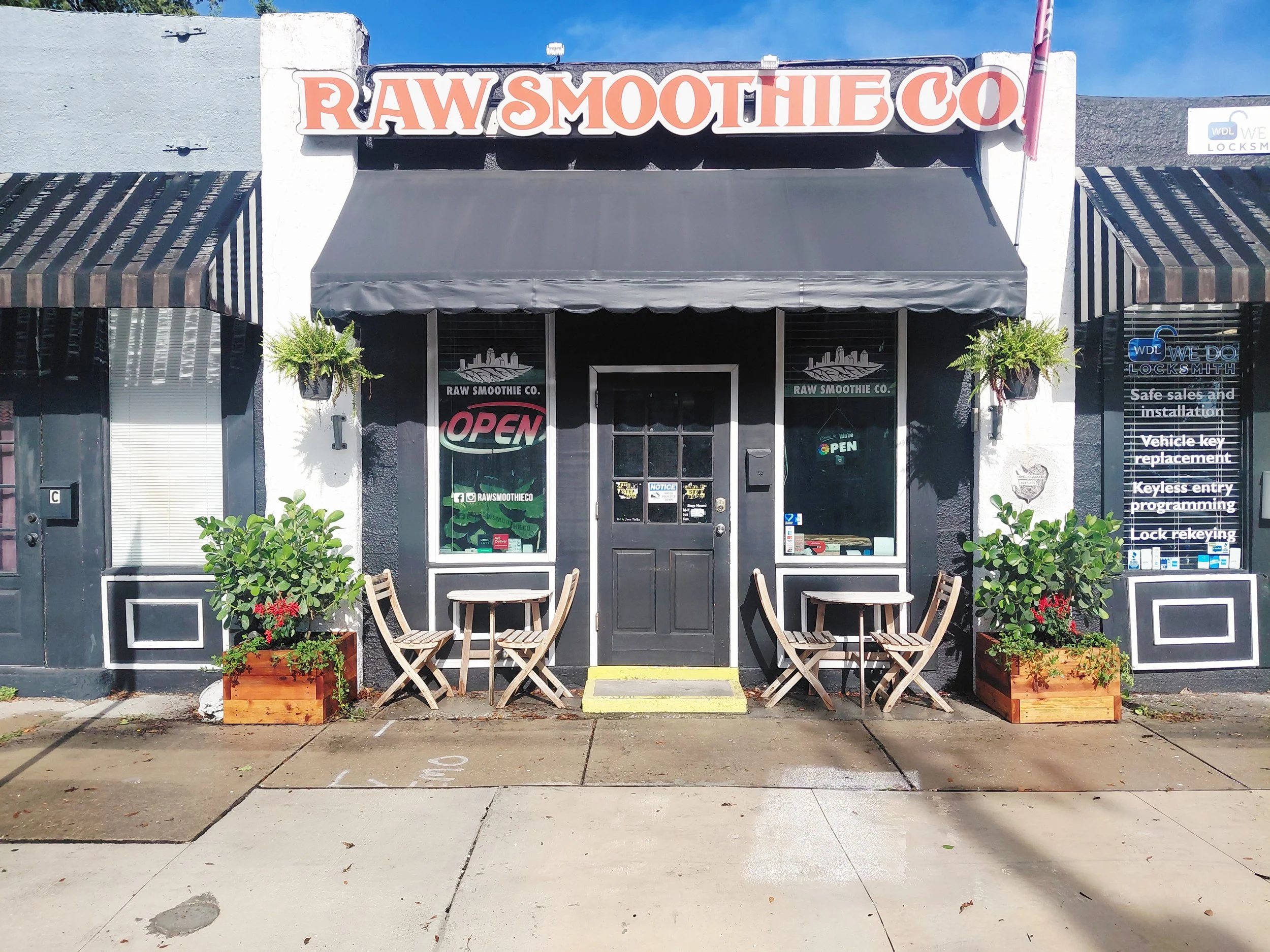 Old West Tampa, FL-Commercial curb appeal installation for Raw Smoothie Co. Custom raised beds with Clusia hedging and Perennial Peanut groundcover create an inviting storefront. 