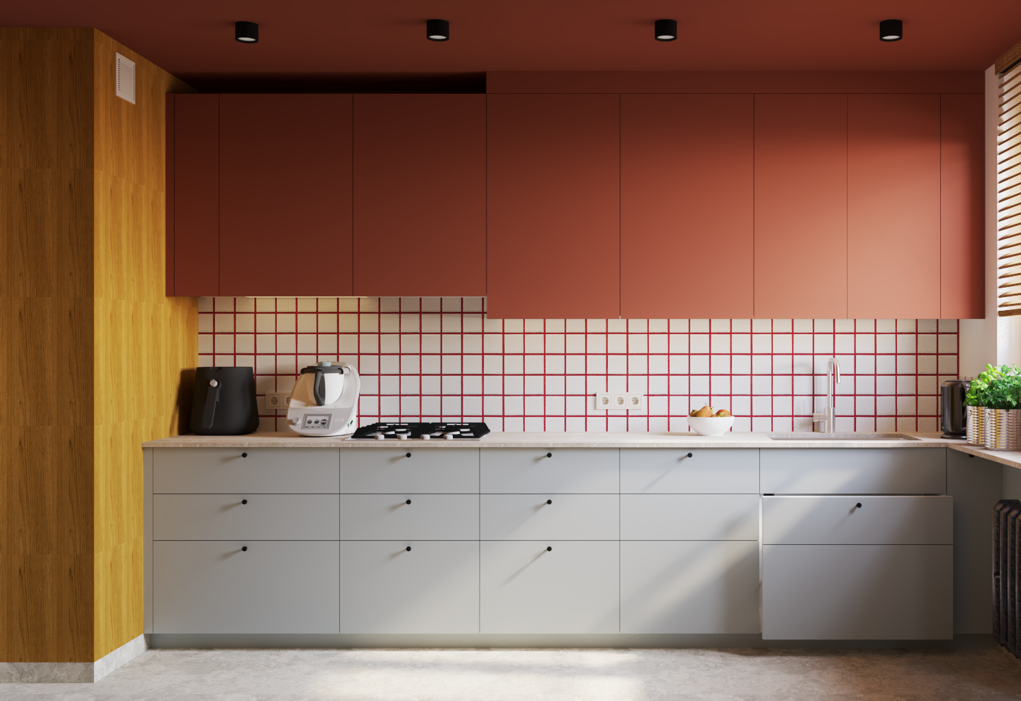 Modern kitchen with lower cabinets, red upper cabinets, a red grid backsplash, and a wooden accent wall. Appliances include air fryer, multi-cooker, and a electric kettle. There is a bowl of apples, a sink with a faucet, and a potted plant on the counter near a window with wooden blinds.