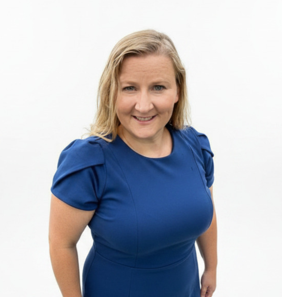 Firm owner, smiling, blond hair wearing a blue dress.