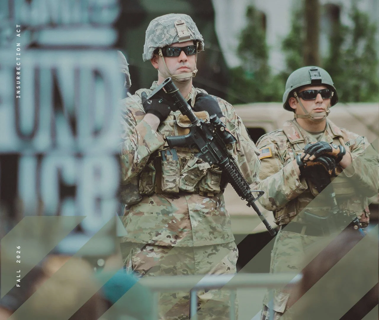 Two soldiers in camouflage uniforms with helmets and sunglasses standing outdoors, one holding a rifle.