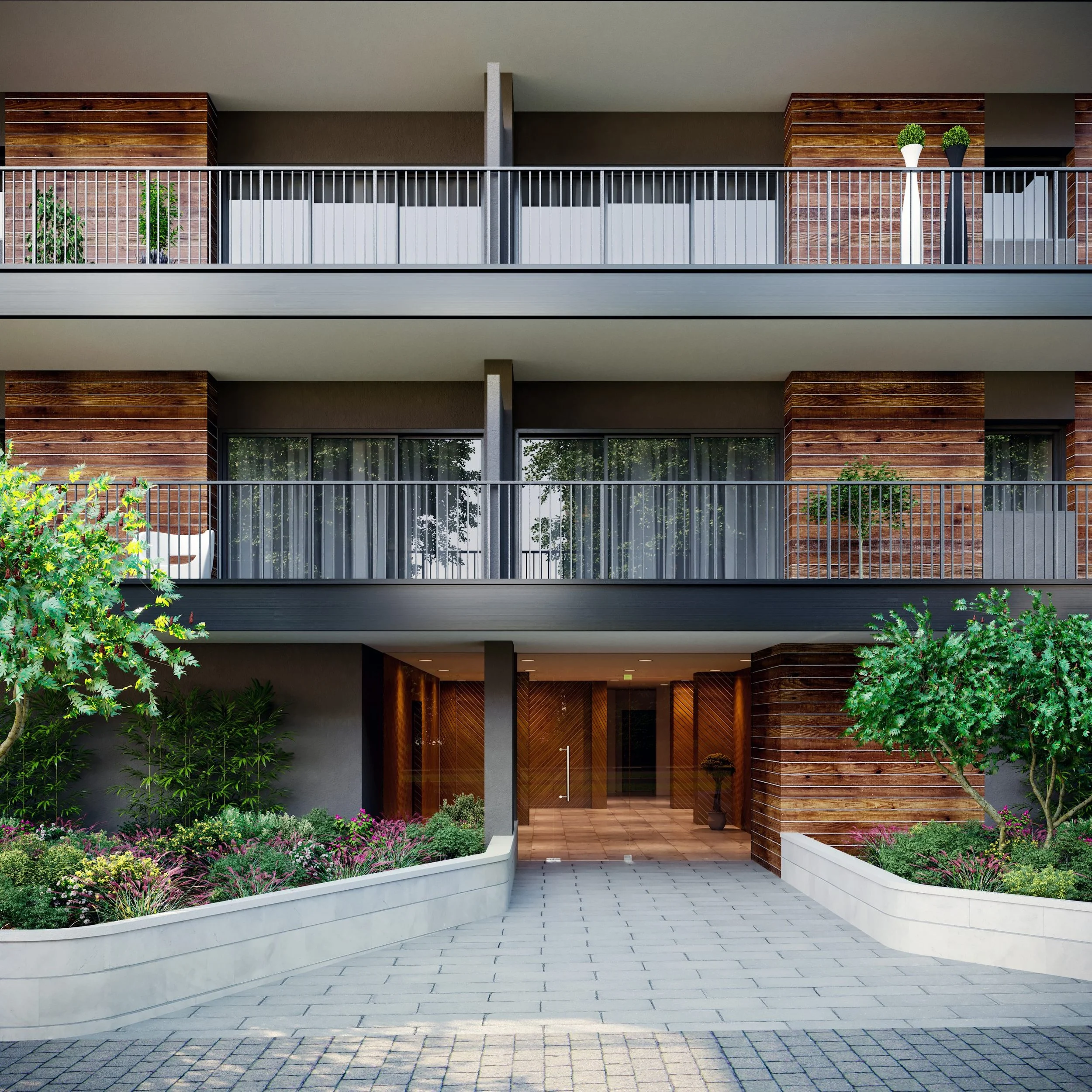 Modern residential building with three floors, featuring a combination of brick and wooden exterior, balcony with metal railing, and landscaped front yard with colorful flowers and green trees.