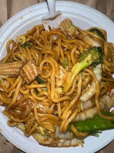Plate of stir-fried noodles with vegetables, baby corn, and green peppers.