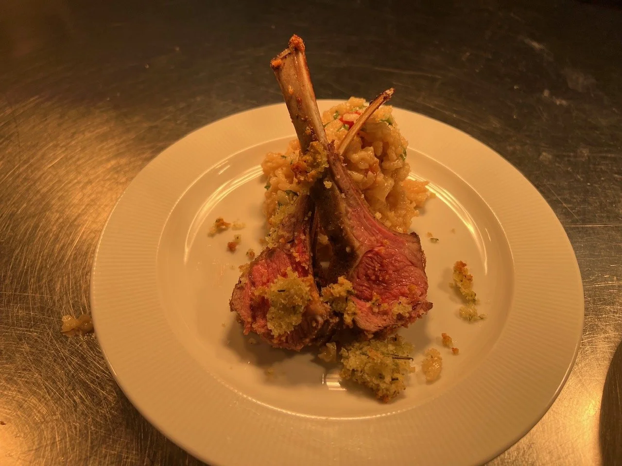 Lamb chops with a side of mashed vegetables on a white plate