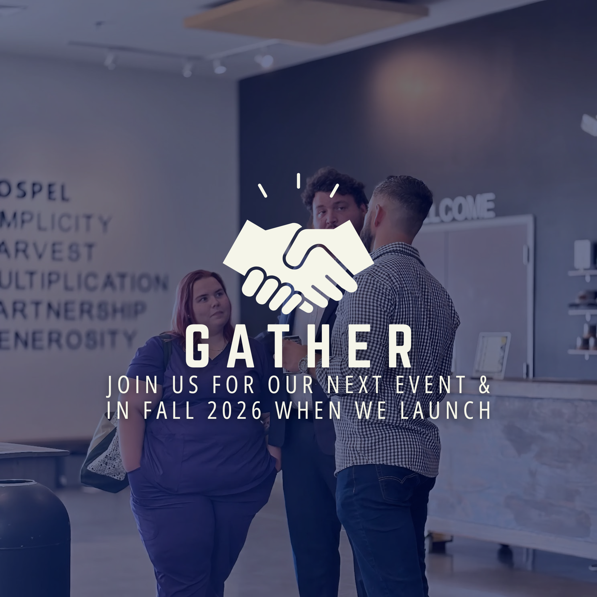 Two men shaking hands during a conference or event, with other people in the background and a sign with the words "GATHER" visible.