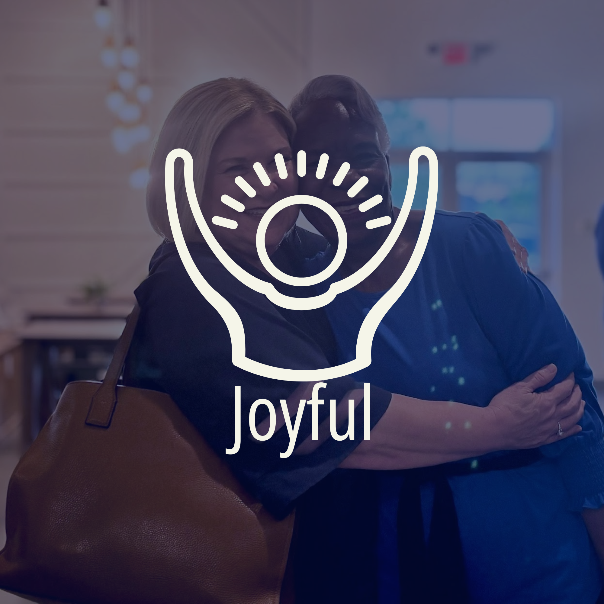 A man and woman embracing and smiling inside a building, with the word 'joyful' and a hand icon overlay on the image.