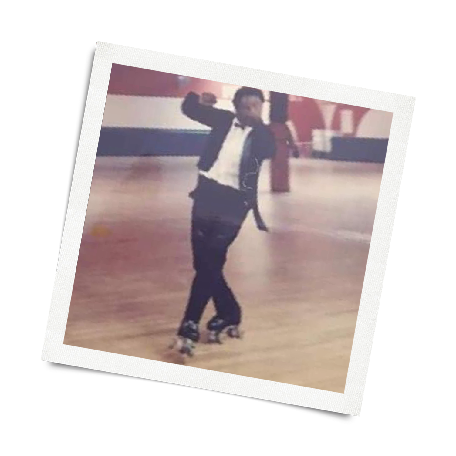 A person ice skating indoors, wearing black clothing, with one arm raised and giving a thumbs-up.